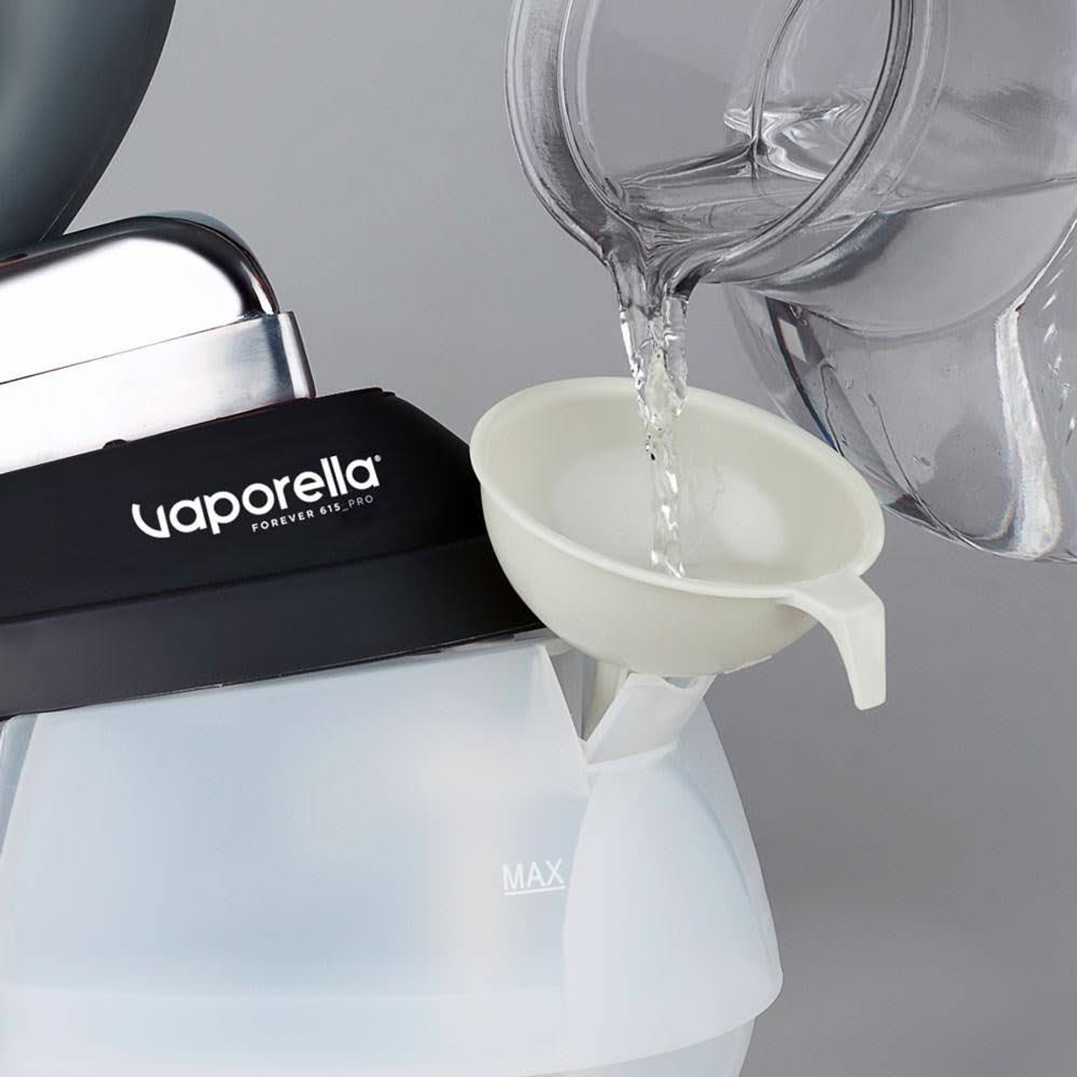 Una persona vierte agua en una plancha blanca. Se utiliza un embudo para llenar la plancha. La marca es Vaporella.