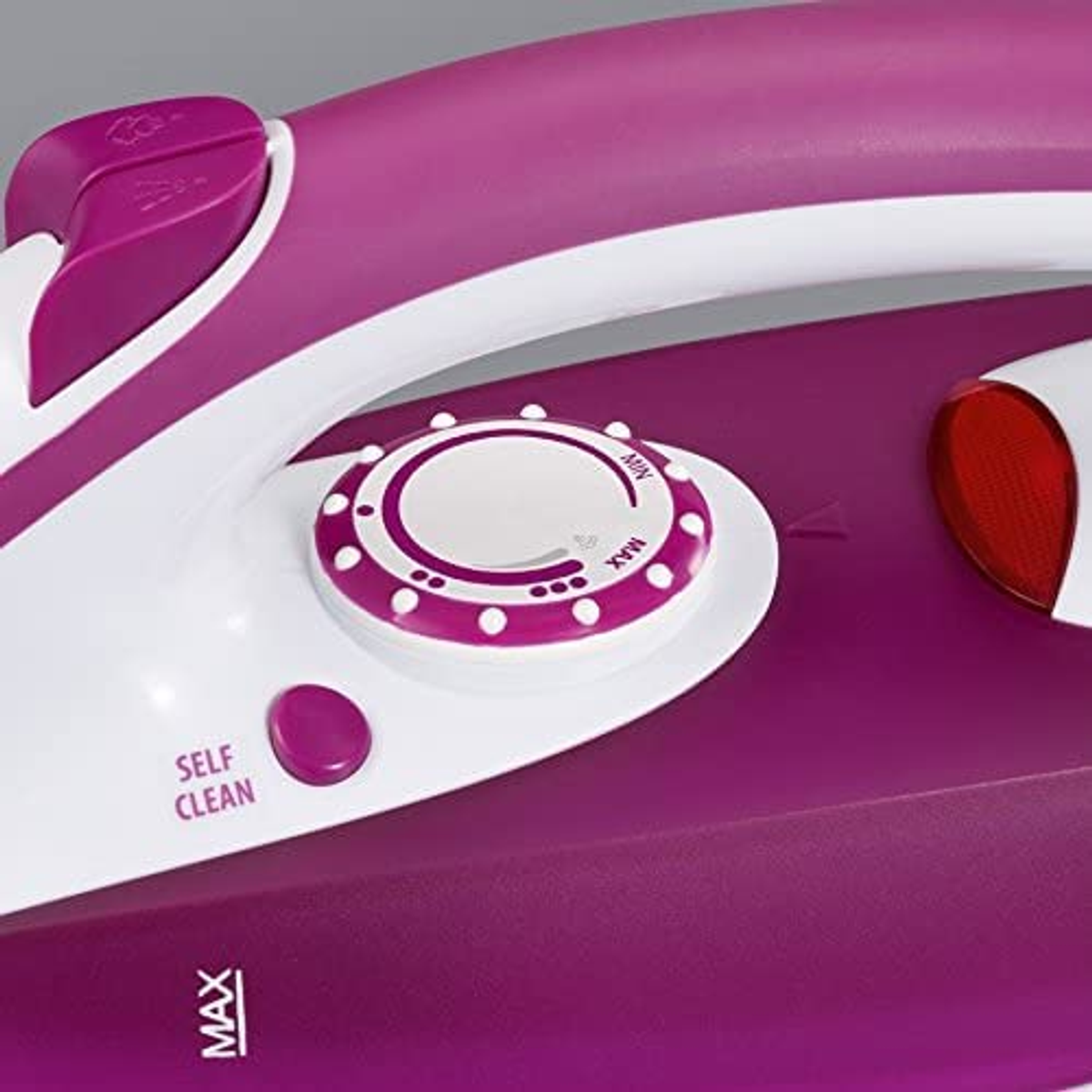 A close-up of a purple and white iron with a dial for temperature control.