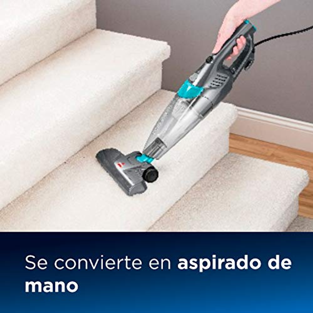 Un aspirateur à main nettoie les escaliers recouverts de moquette. Texte: Se convertit en aspirateur à main.