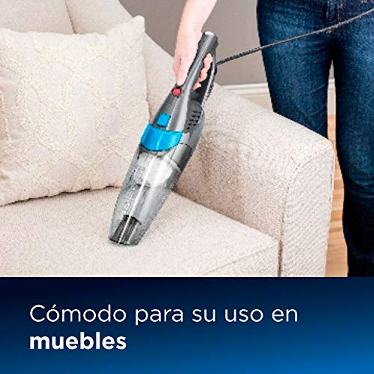 Une personne passe l'aspirateur sur un canapé beige avec un petit aspirateur à main. Texte en bas: 'Comodo'.