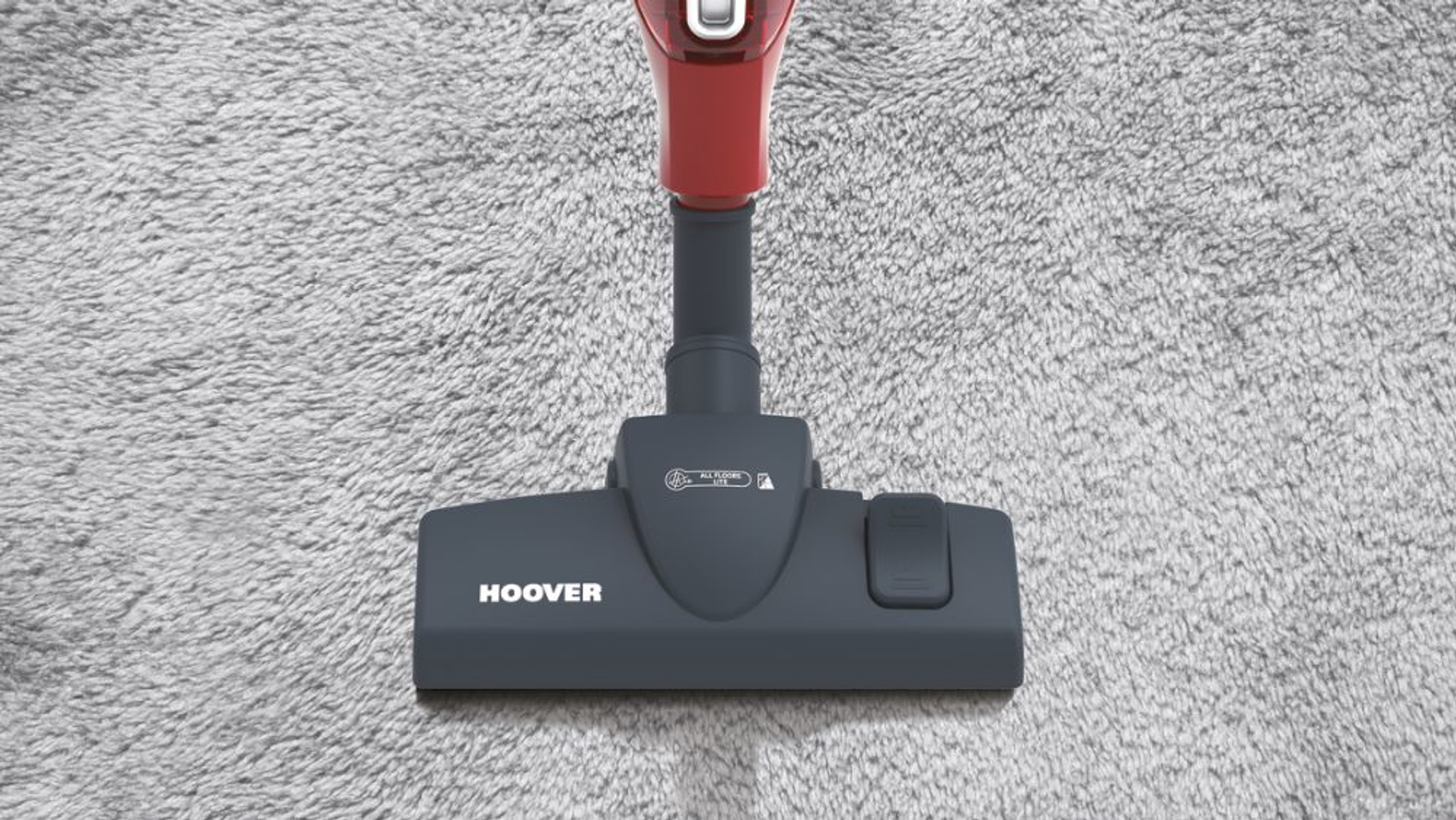 Testa di aspirapolvere Hoover su moquette grigia, con il marchio in evidenza.
