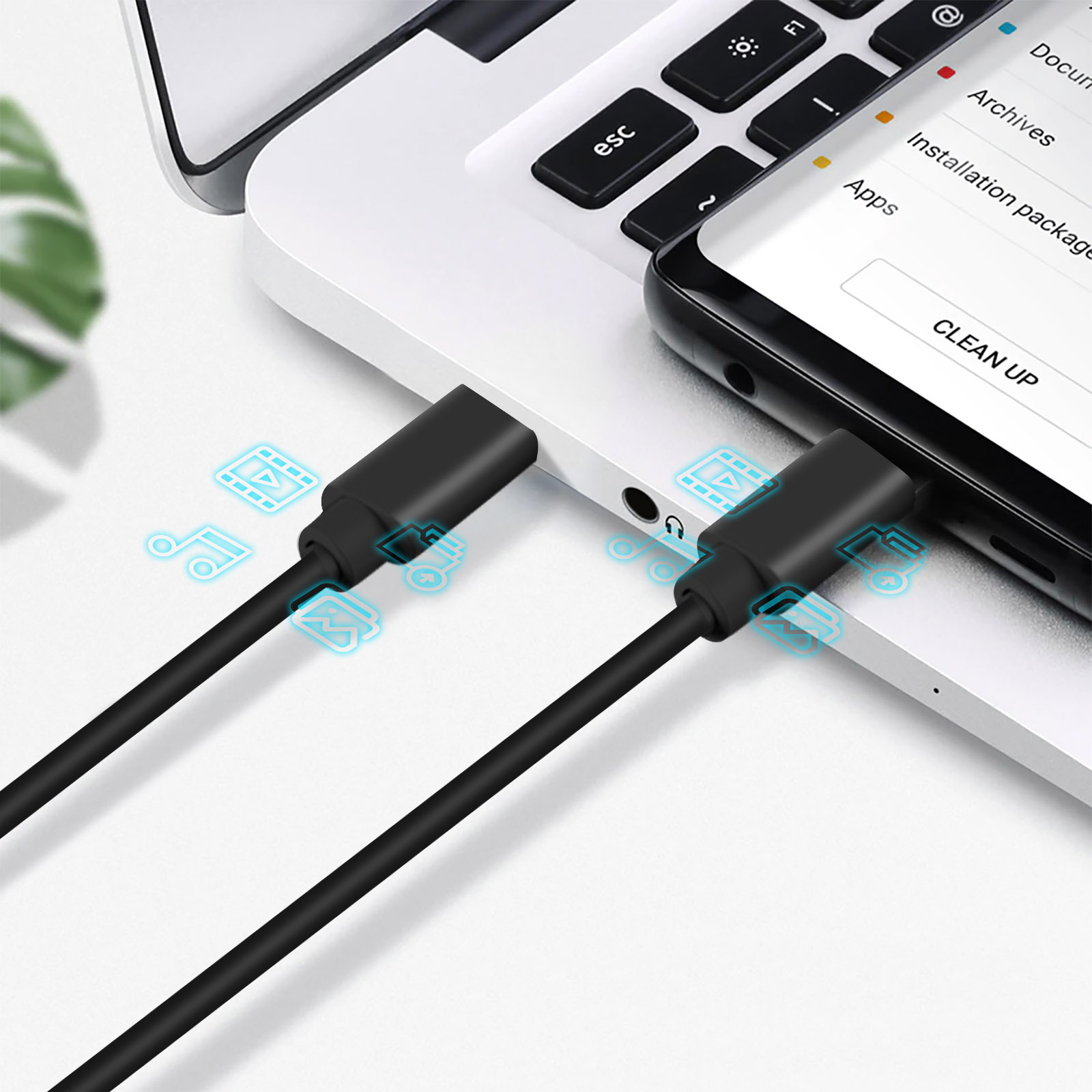Cable de carga negro conectado a una laptop y un teléfono. Fondo blanco.
