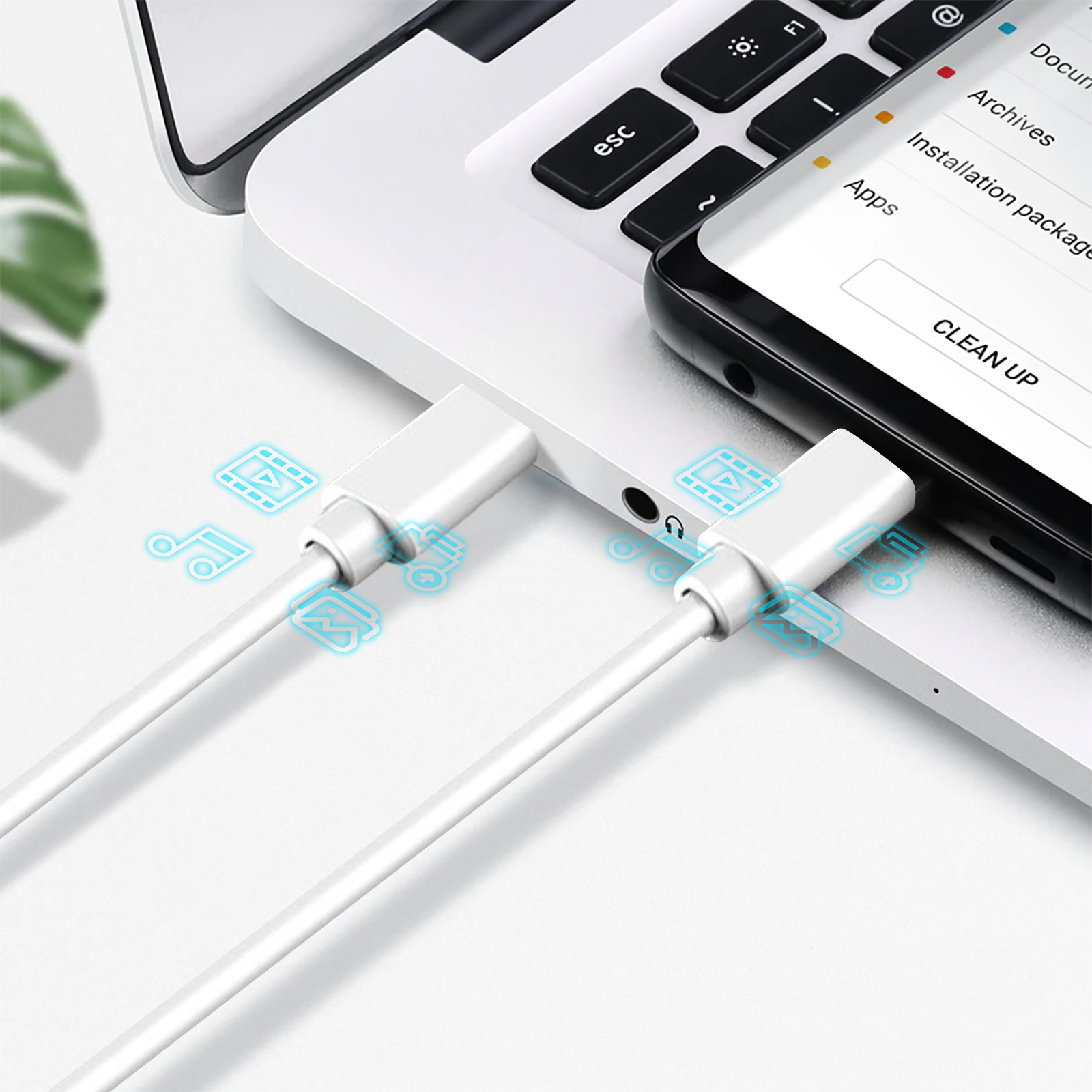 Un cable blanco está conectado a una computadora portátil y a un teléfono. El teléfono muestra aplicaciones y la palabra CLEAN UP.