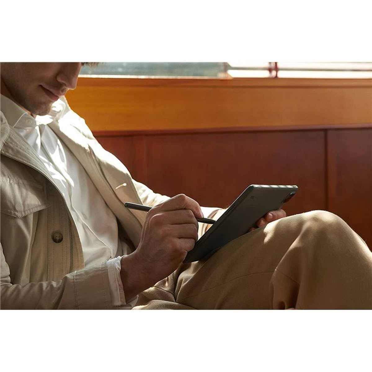 Un uomo usa un tablet e uno stilo al chiuso.