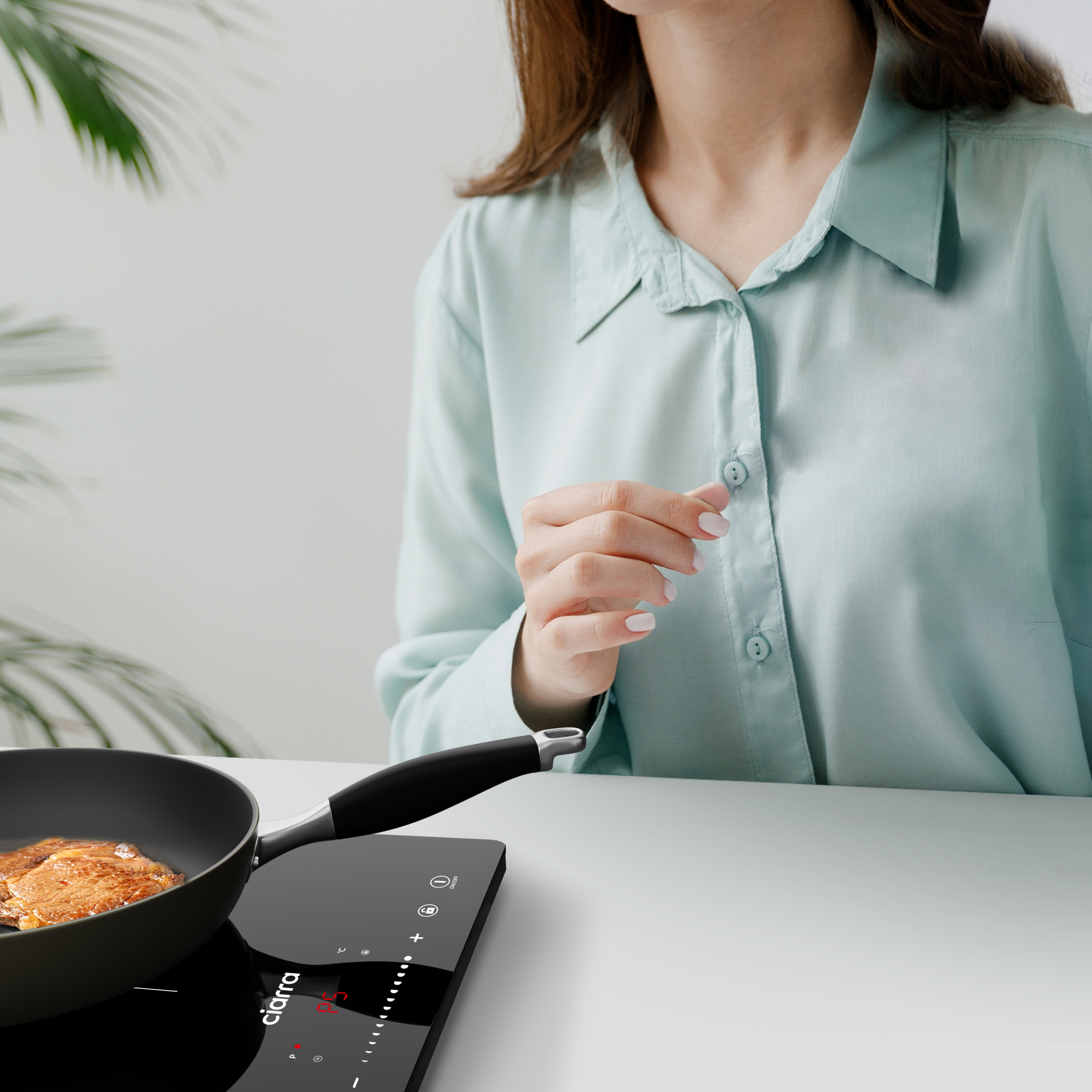 Eine Person kocht Pfannkuchen auf einem schwarzen Induktionskochfeld.