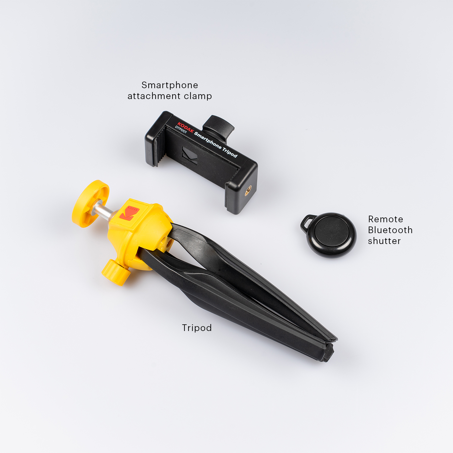 Trípode, abrazadera para teléfono y disparador remoto. Trípode amarillo y negro, abrazadera para teléfono negra, remoto negro.