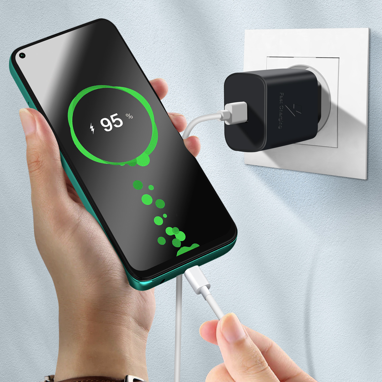 Hand hält grünes Telefon beim Aufladen. Weißer Hintergrund.