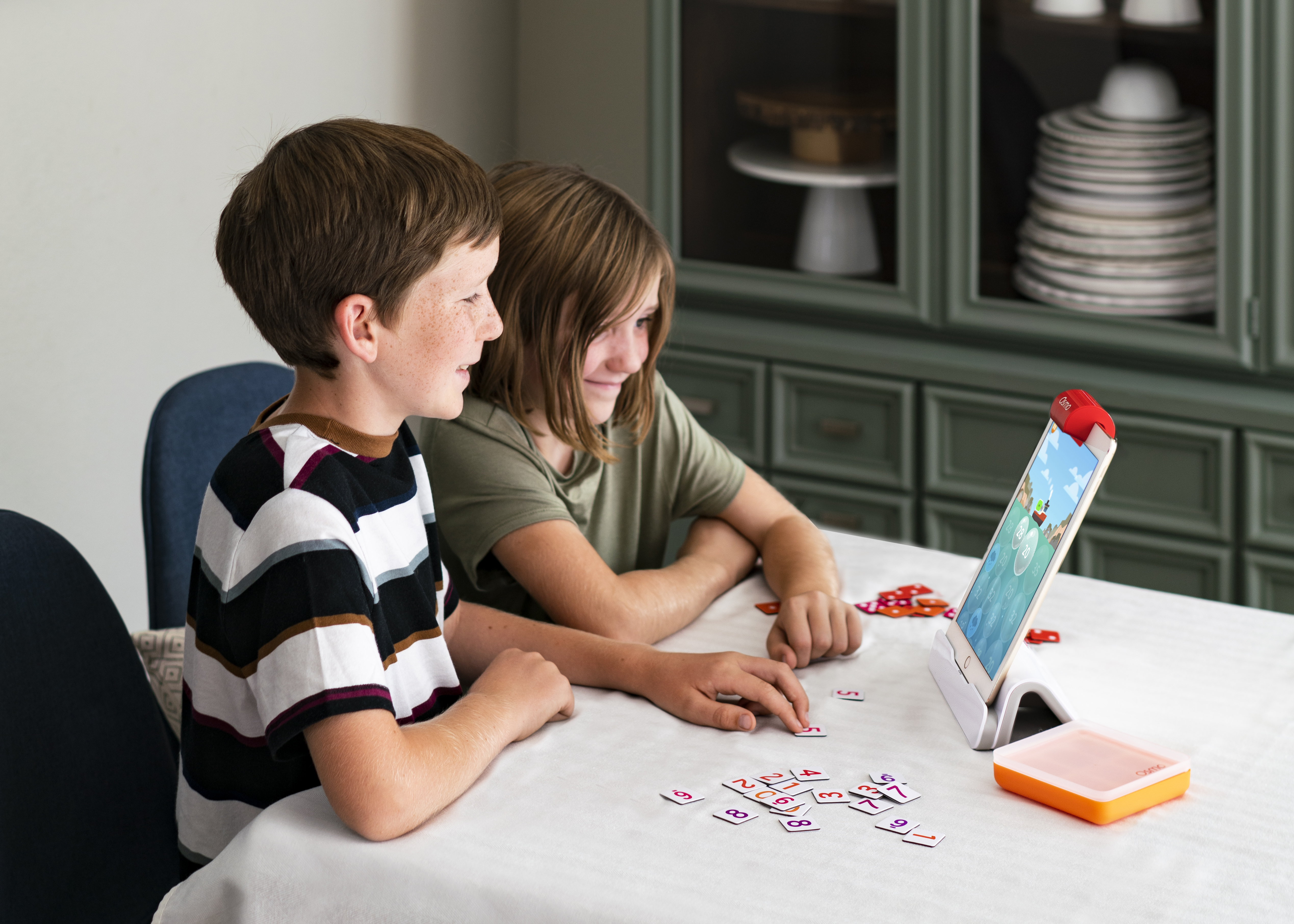 Due bambini giocano a un gioco con numeri su un tablet.