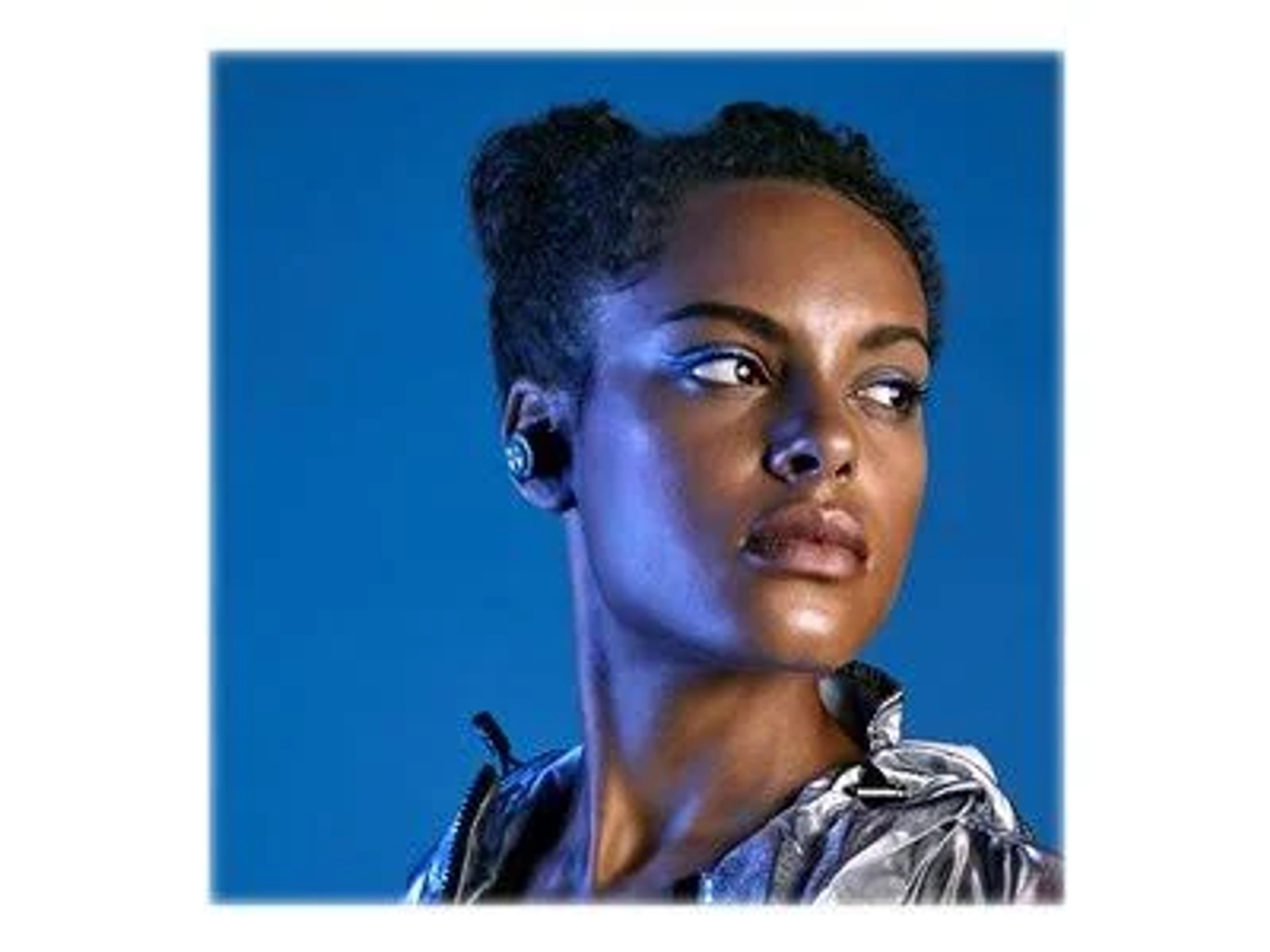Una donna che indossa un auricolare. Lo sfondo è blu.