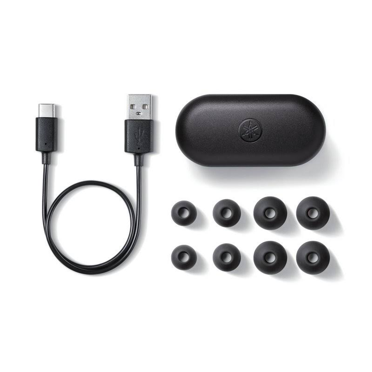 Ohrhörer, Ladekabel und Hülle auf weißem Hintergrund.