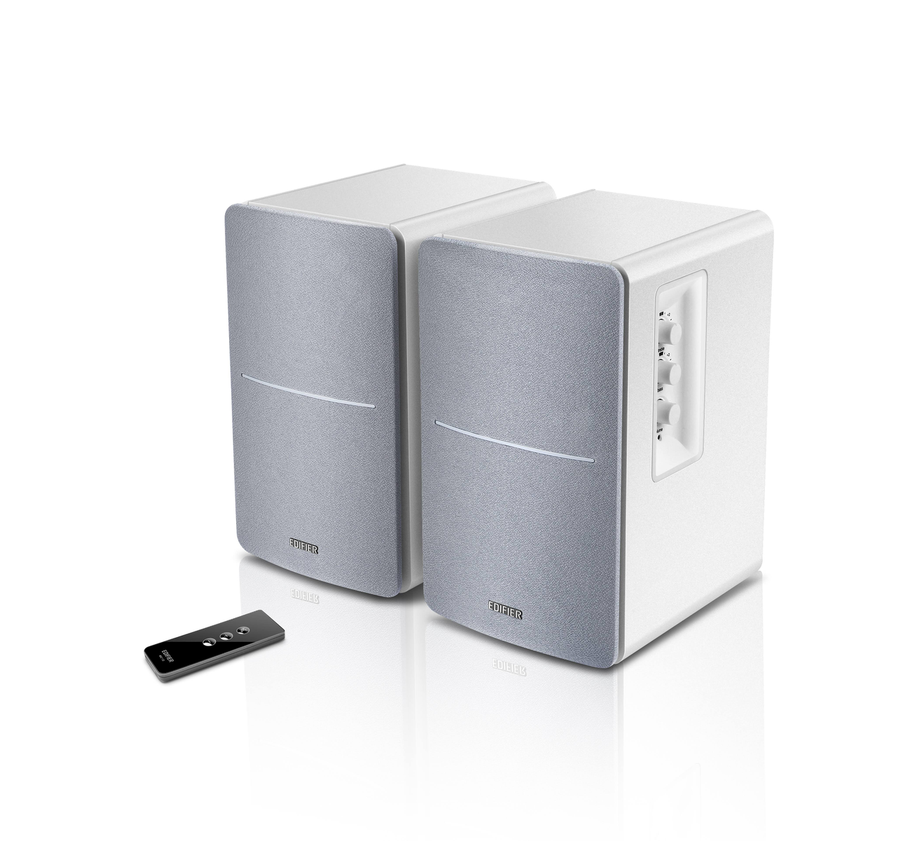 Dwa białe głośniki i pilot na białej powierzchni.