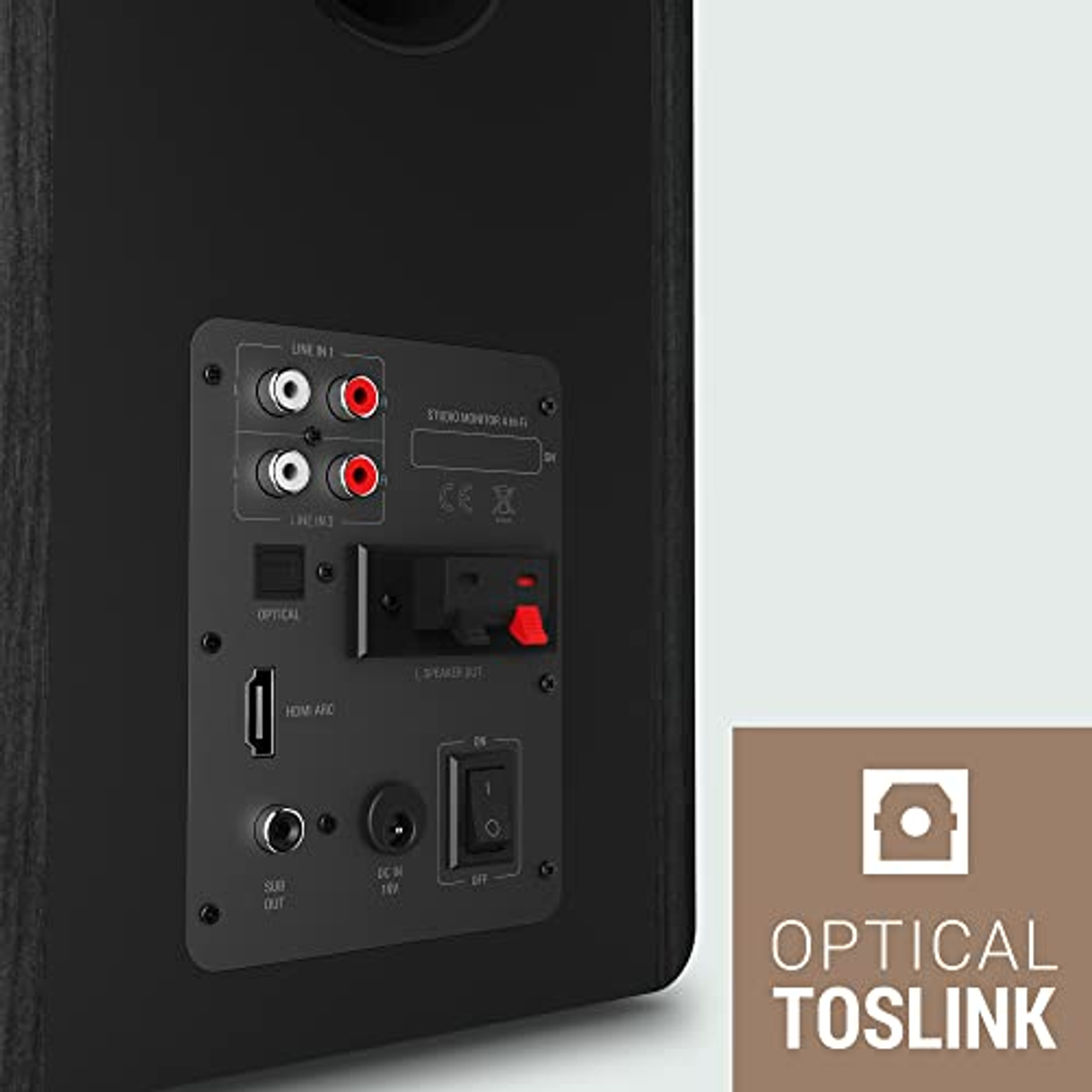 Panel trasero de altavoz negro con puertos y conexiones. Fondo blanco, texto óptico Toslink.