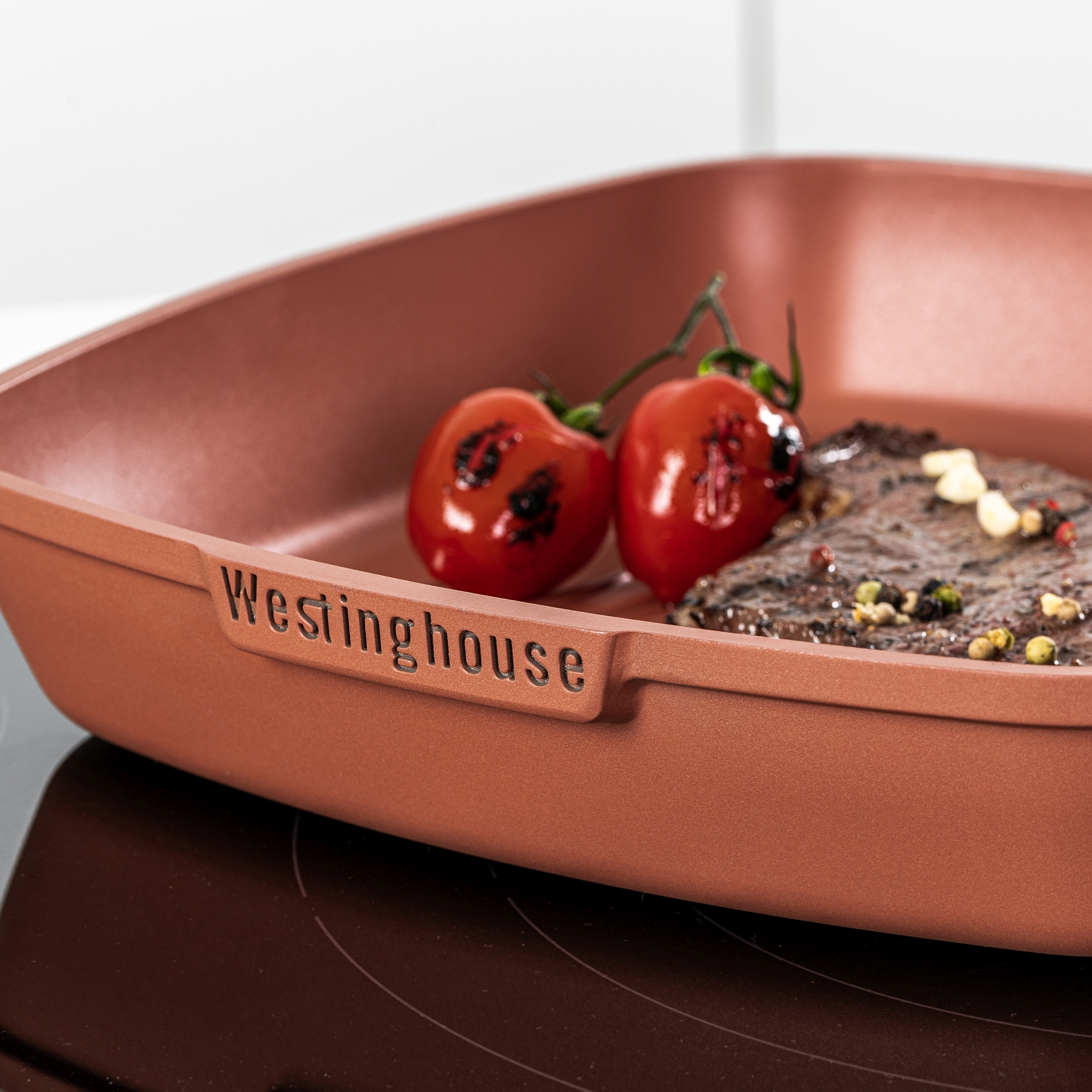 Braune quadratische Pfanne mit Tomaten und Steak, beschriftet Westinghouse.