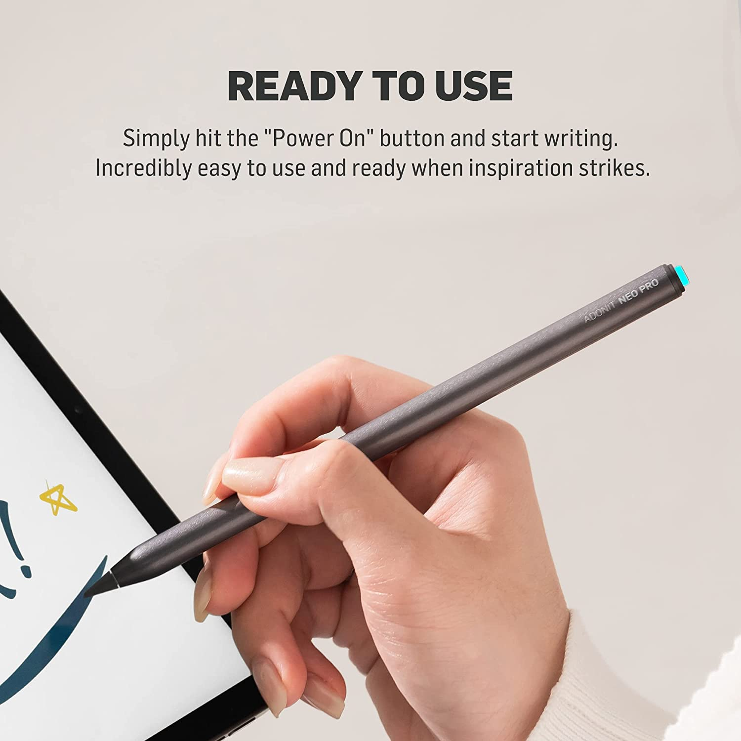 Hand hält einen grauen Stift. Im Hintergrund ein Tablet mit Zeichnung. Text auf dem Bildschirm.