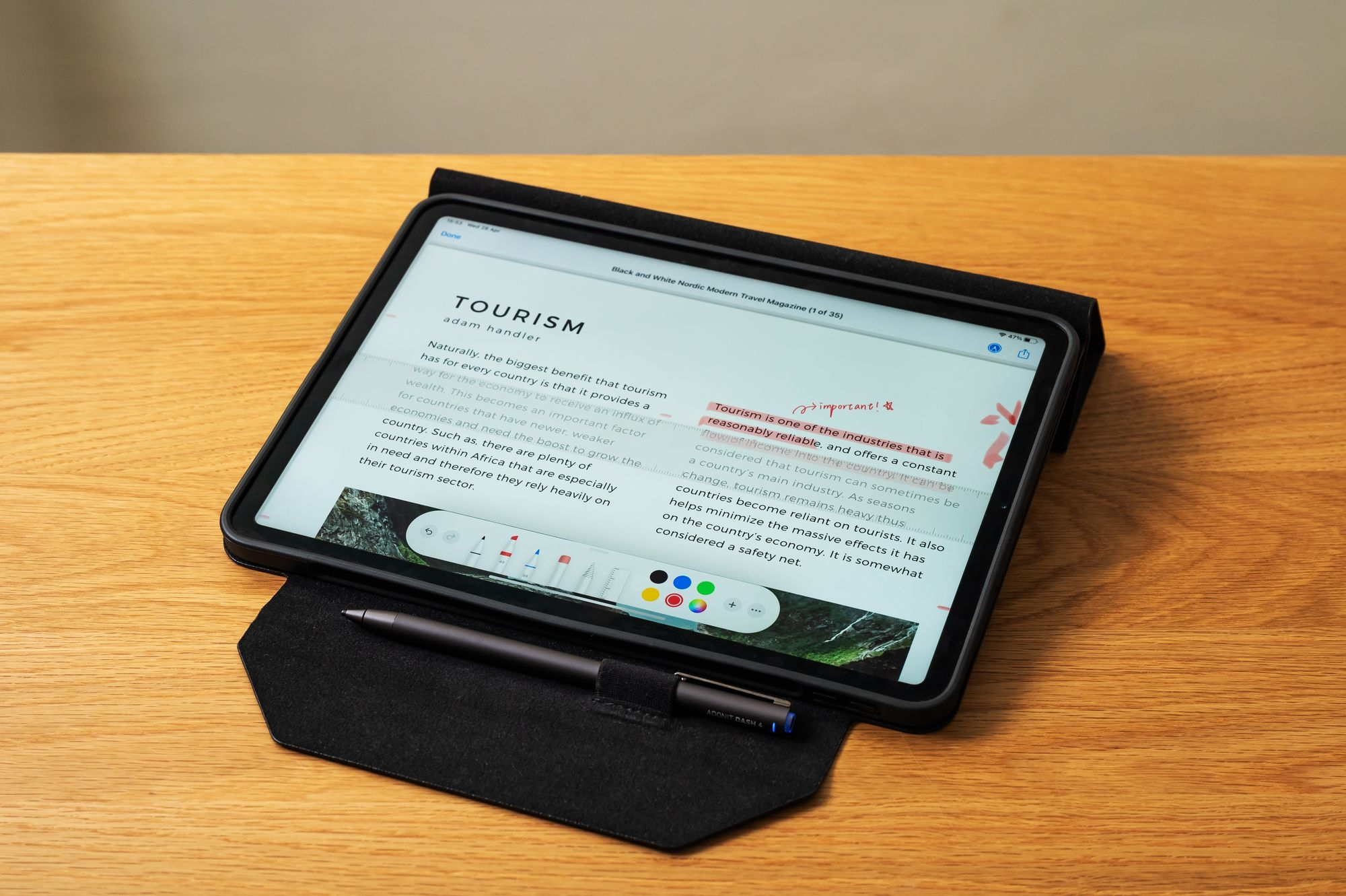 Un tablet con un documento aperto su un tavolo di legno, una penna poggia sulla copertina.
