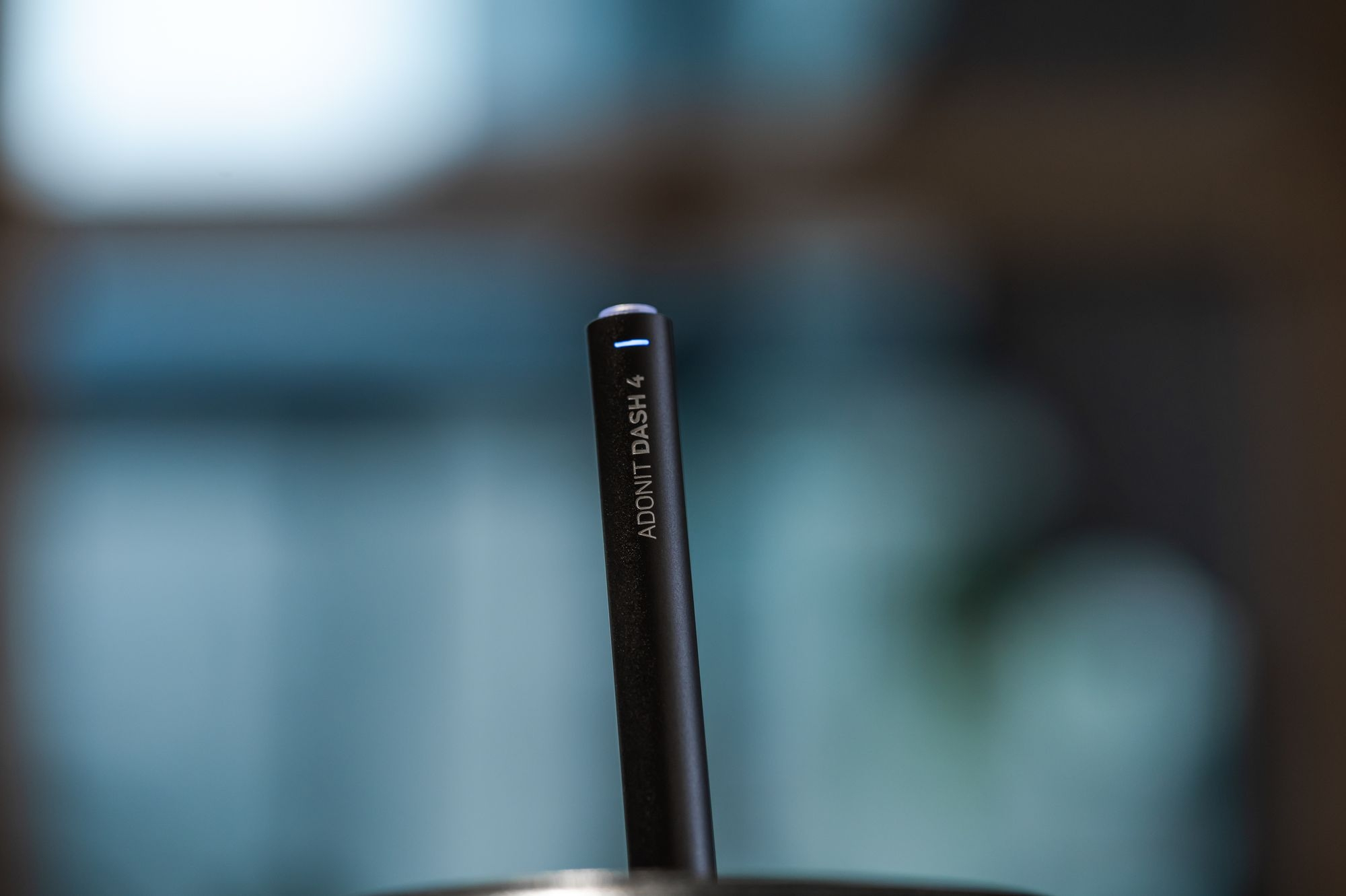 Una penna stilo nera con la parte superiore illuminata di bianco. La penna è etichettata 'ADONIT DASH 4'.