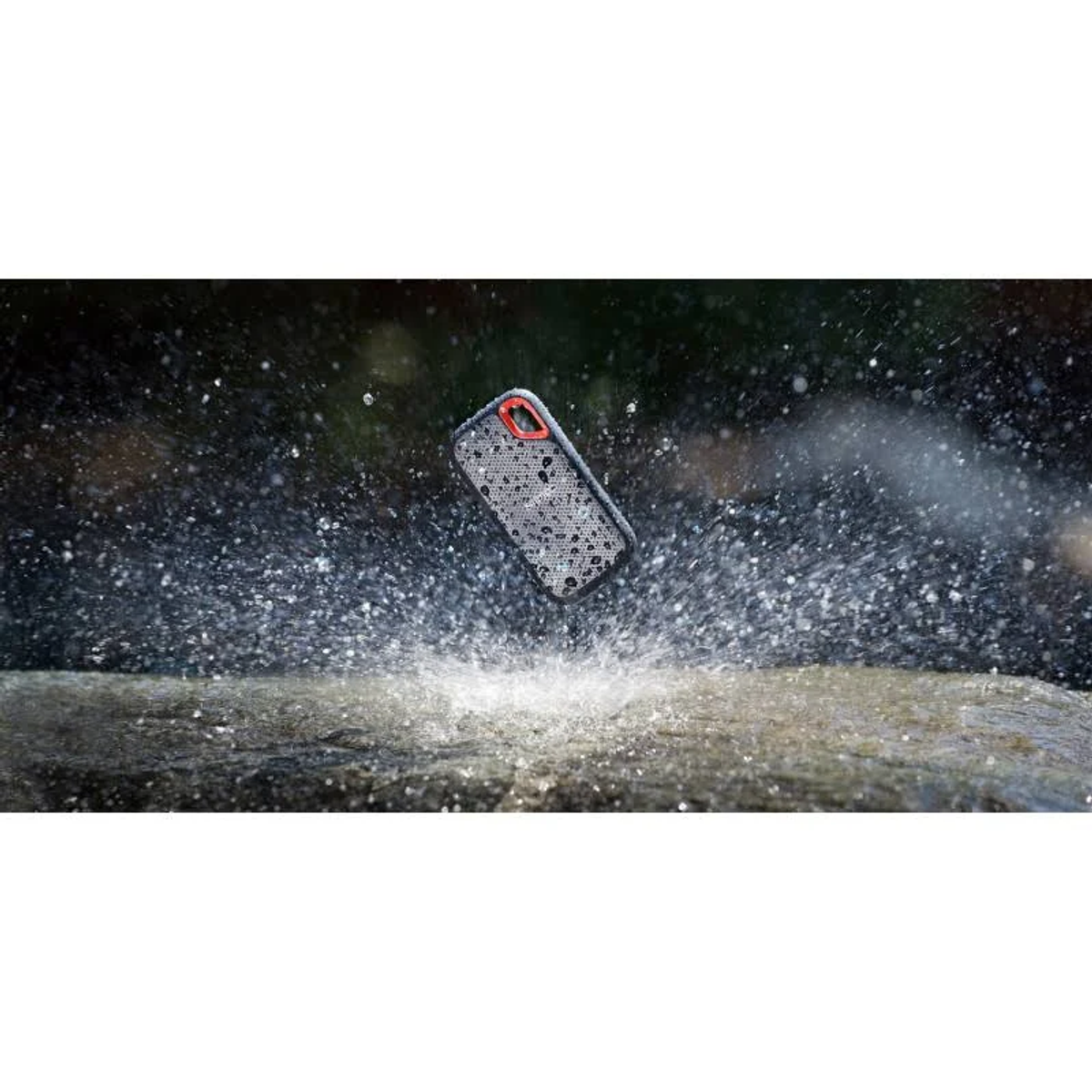 Un teléfono en una funda está salpicado de agua. El teléfono es gris y la funda tiene un patrón.