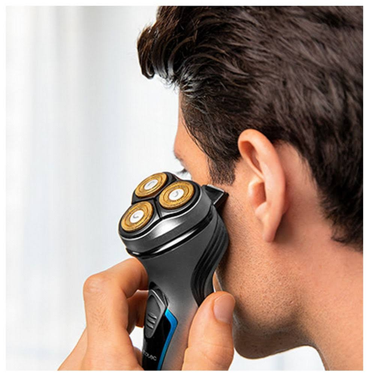 Mężczyzna golący się golarką elektryczną, zbliżenie na jego twarz i golarkę.