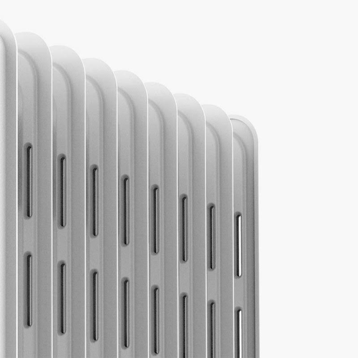 Zbliżenie białego grzejnika z pionowymi prętami i szczelinami.