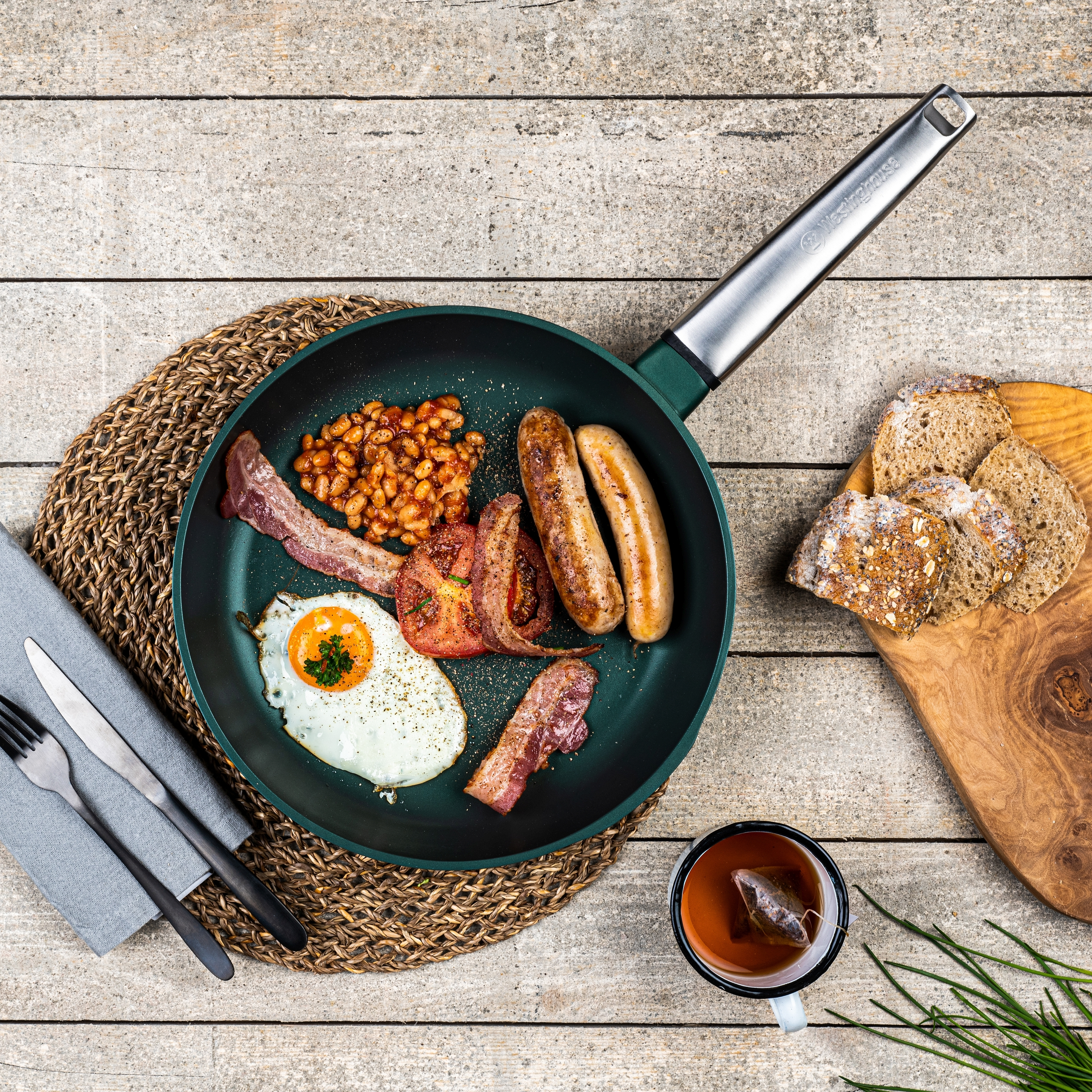 Bratpfanne mit Frühstück, einschließlich Eier, Speck, Bohnen, Würstchen und Brot.