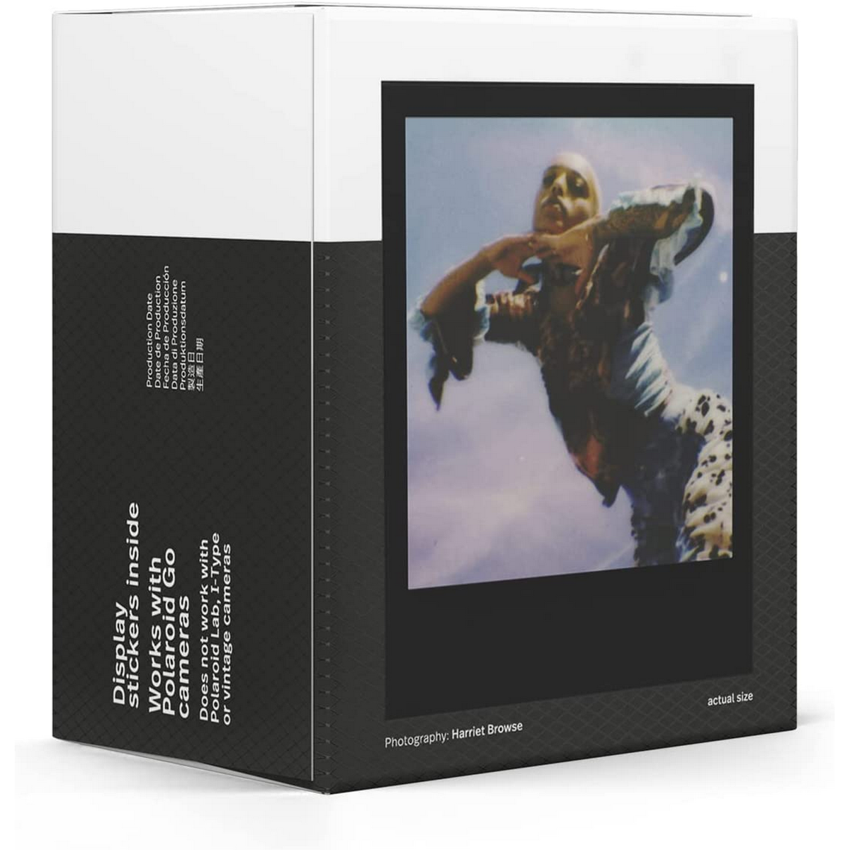 Caja con foto Polaroid, mujer en azul y estampado leopardo. Texto sobre pegatinas y cámaras.