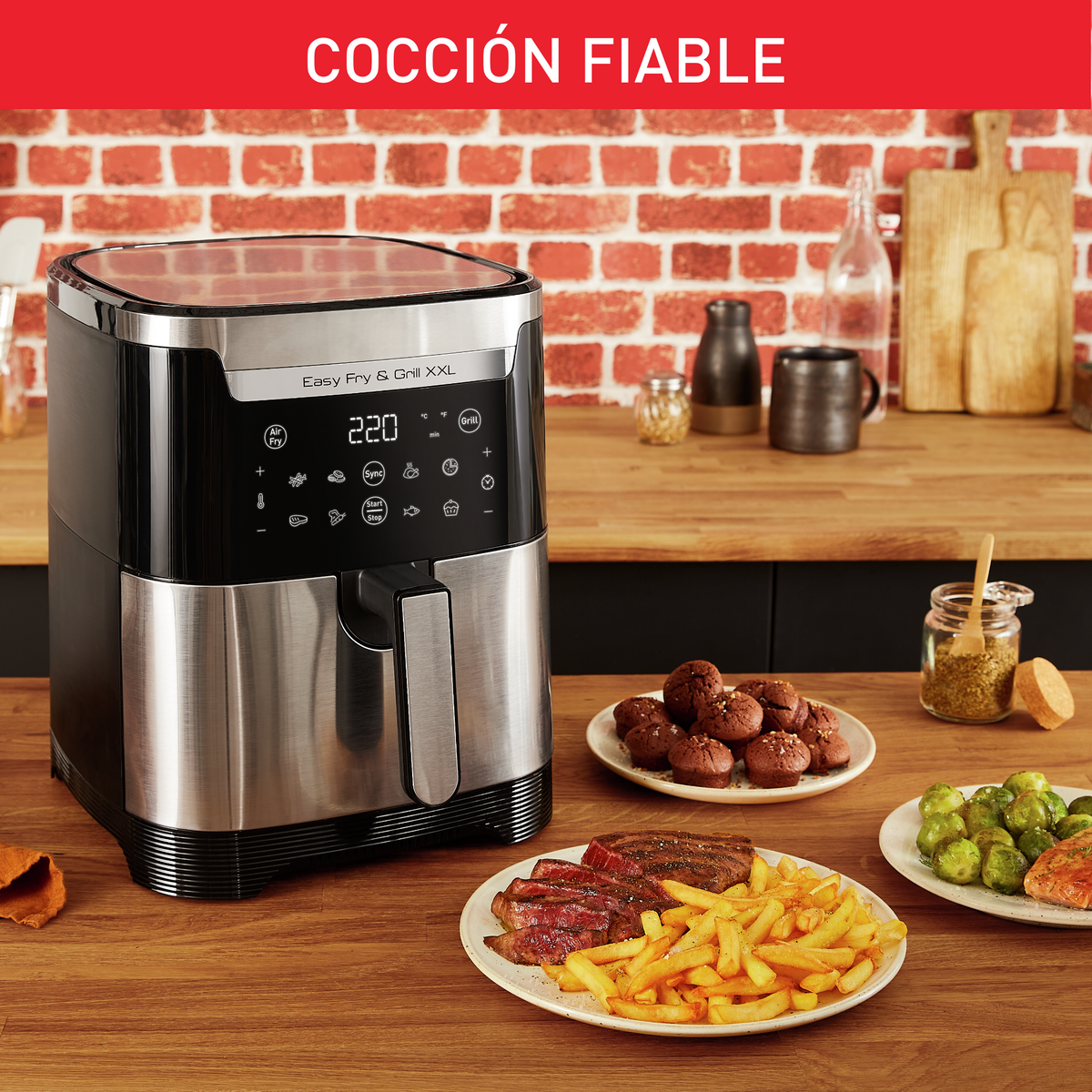 Frytkownica beztłuszczowa z jedzeniem na stole: frytki, stek, warzywa, chleb.