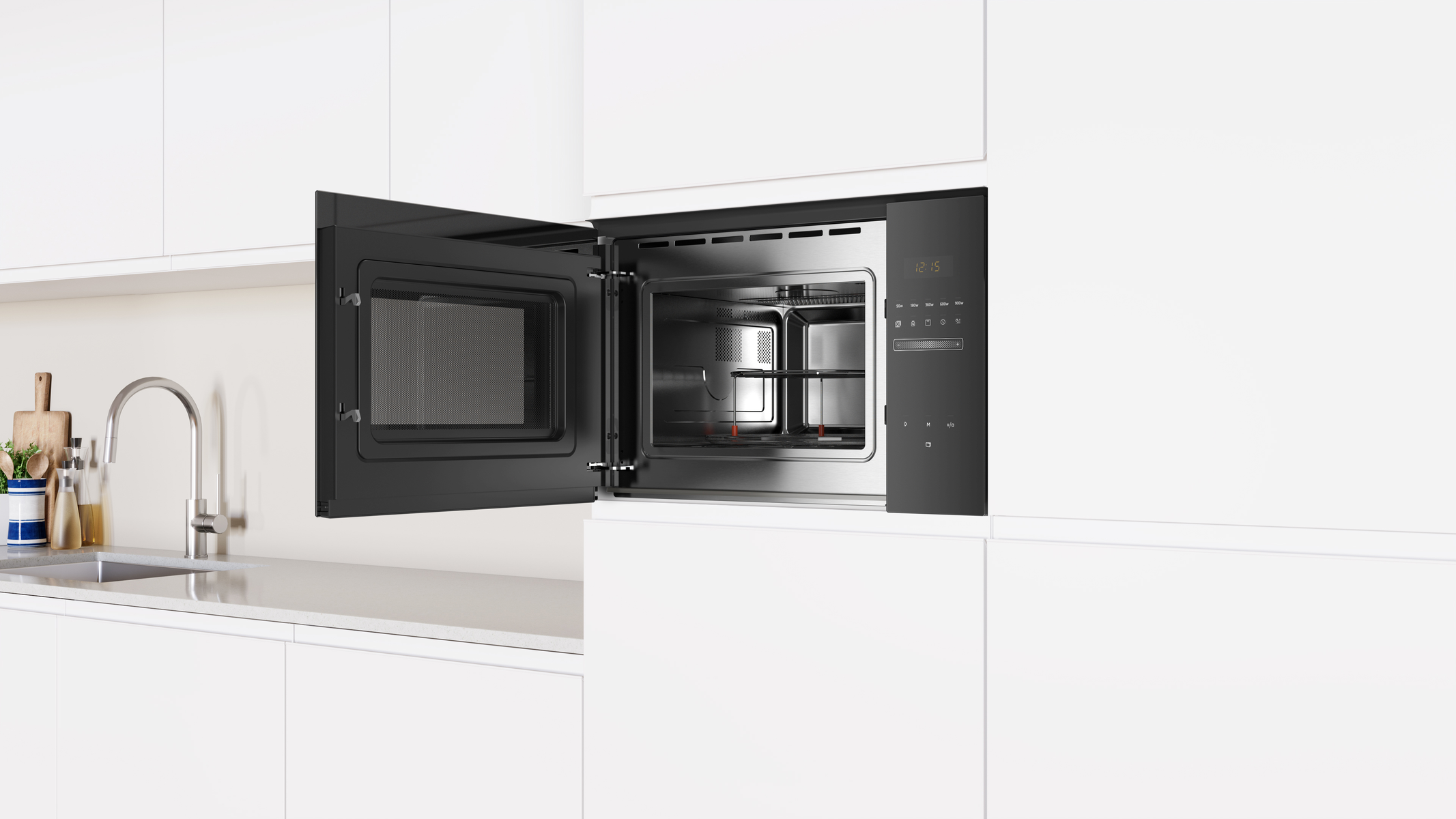 Kuchenka mikrofalowa w białej kuchni. Otwarte drzwi. Widoczne wnętrze. Białe szafki.