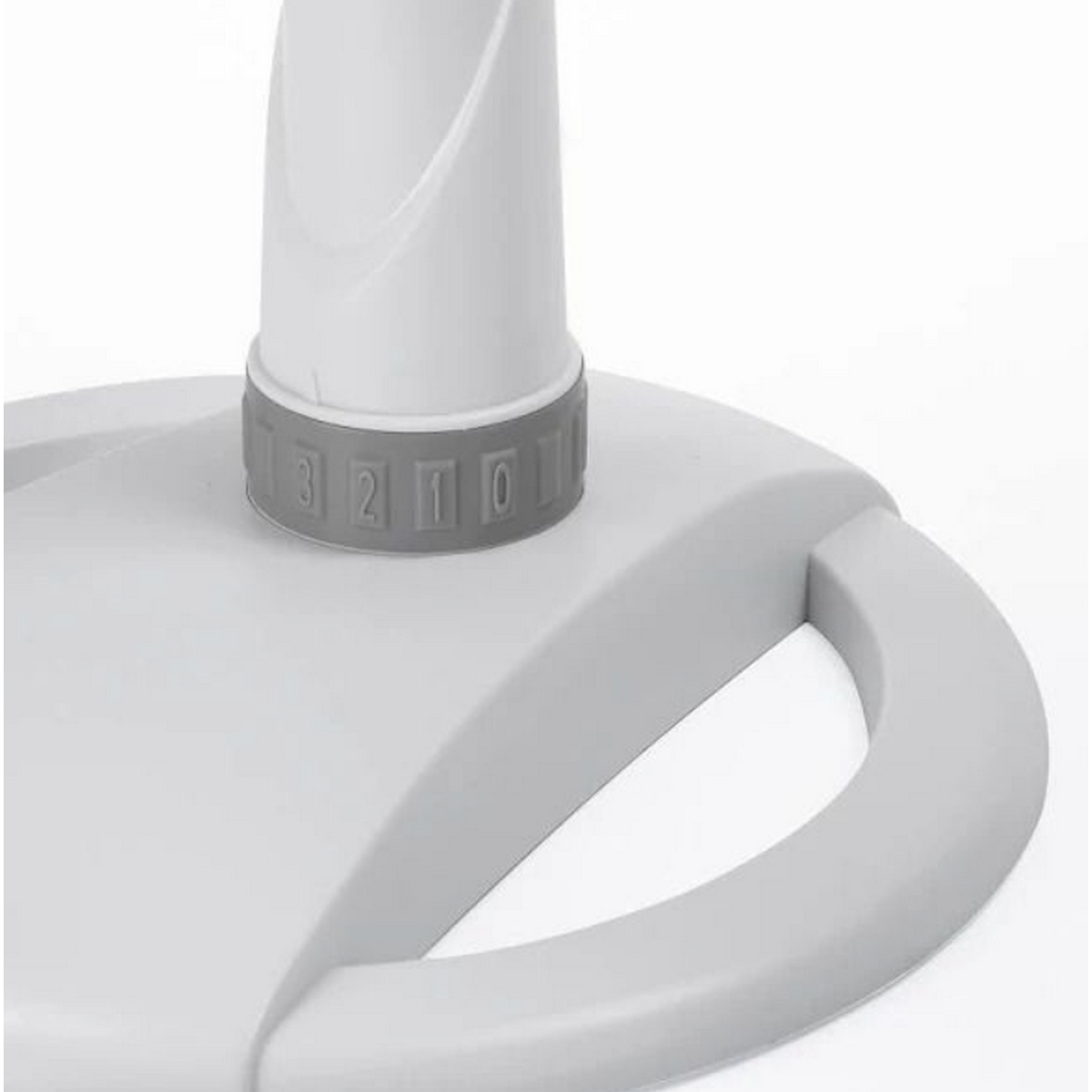 Primer plano de una base blanca y gris con un asa y un dial numerado, probablemente parte de un dispositivo.