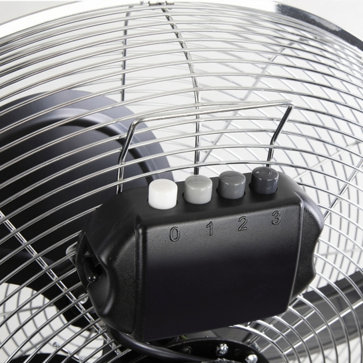 Primer plano de un ventilador metálico, con botones de control de velocidad 0, 1, 2, 3. Blanco.