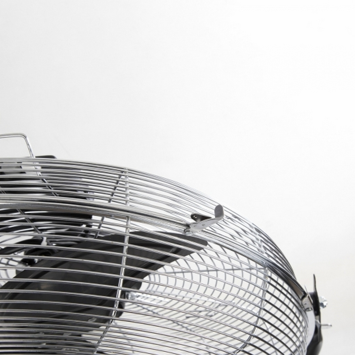 Primer plano de un ventilador metálico con fondo blanco.