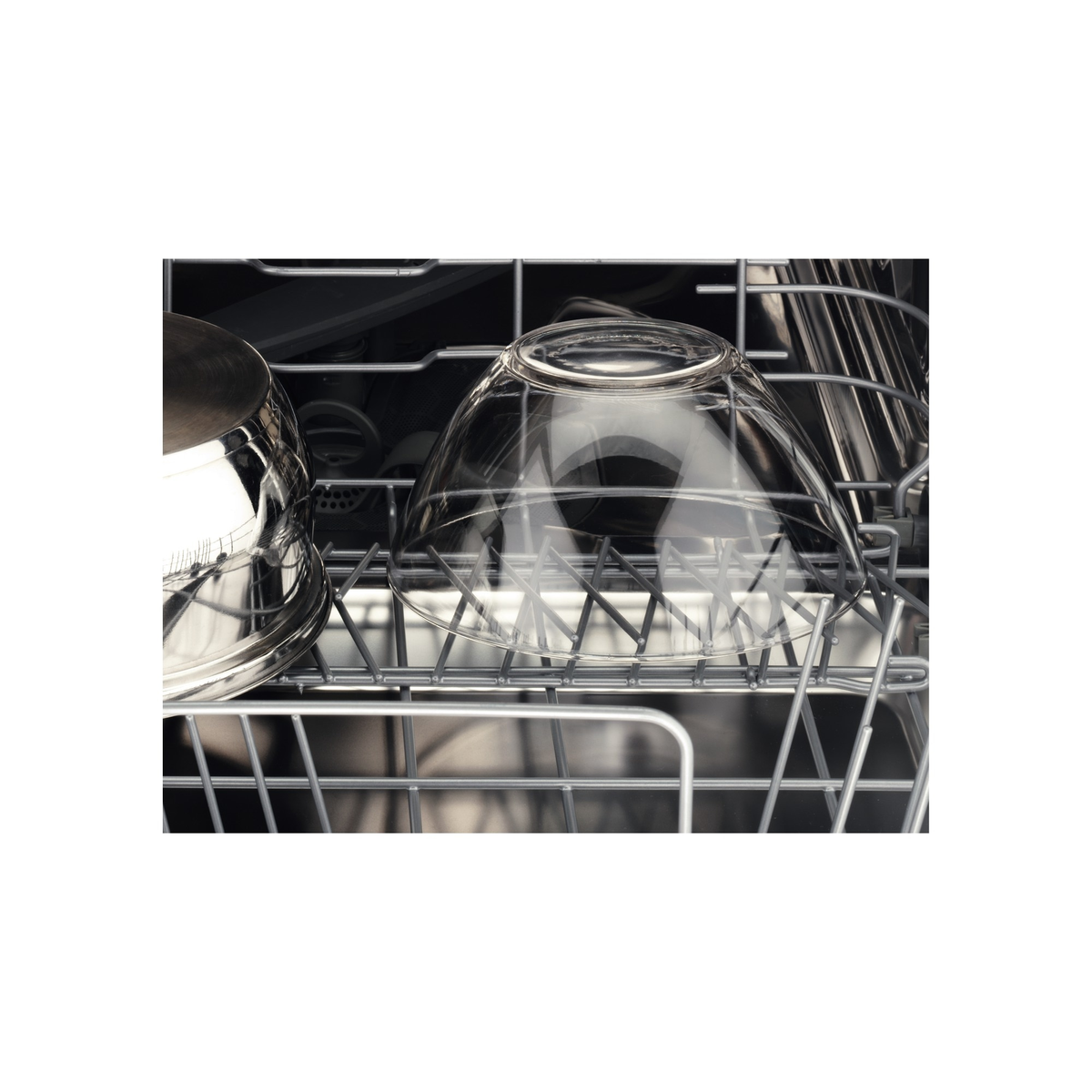Szklana miska w koszu zmywarki, wnętrze ze stali nierdzewnej.
