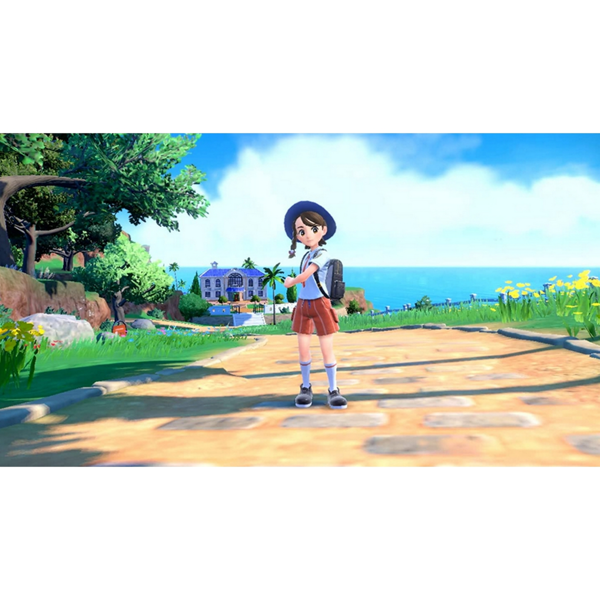 Dziewczyna w mundurku szkolnym, stojąca na ścieżce z morzem i górami w tle.