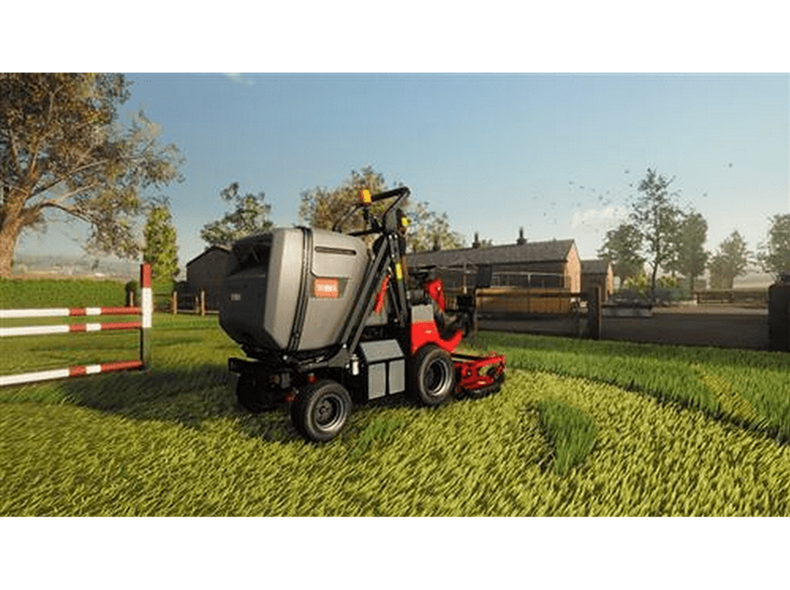 Een zitmaaier maait gras in een veld. Een witte omheining en gebouwen staan op de achtergrond.