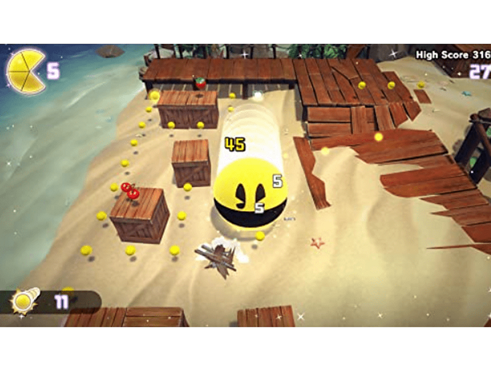 Escena del juego Pac-Man. Pac-Man persigue fantasmas en una playa, con marcadores y puntuaciones altas.
