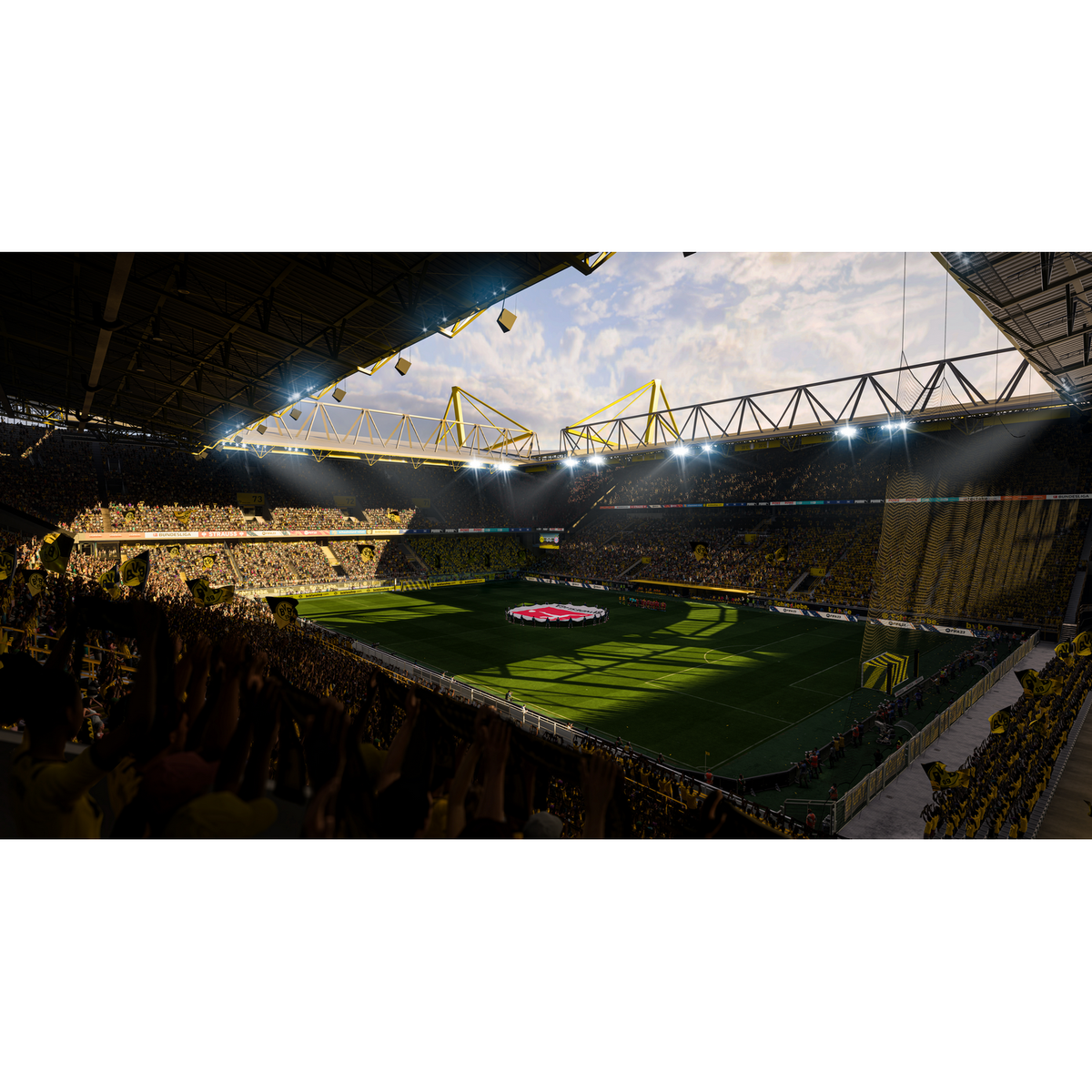 Wnętrze stadionu piłkarskiego. Widok na boisko, trybuny pełne kibiców i dach stadionu. Kolory żółty i zielony.
