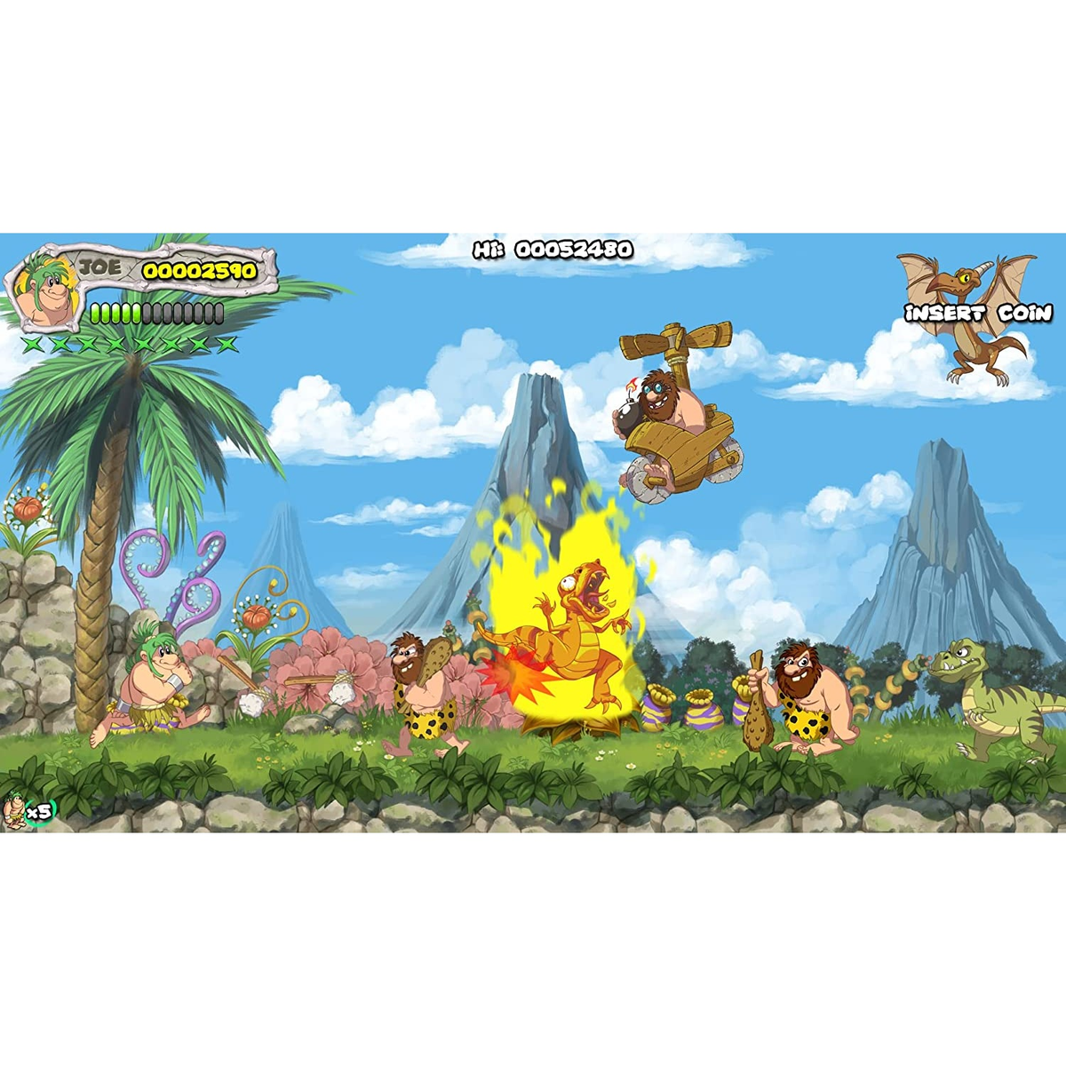 Spielszene mit Cartoon-Höhlenmenschen, Dinosauriern und einem Vulkan. Himmel und Gras im Hintergrund.
