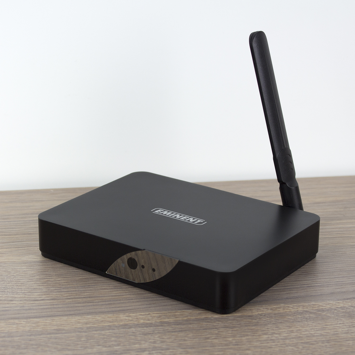 Reproductor multimedia Eminent negro con antena sobre superficie de madera, fondo blanco.