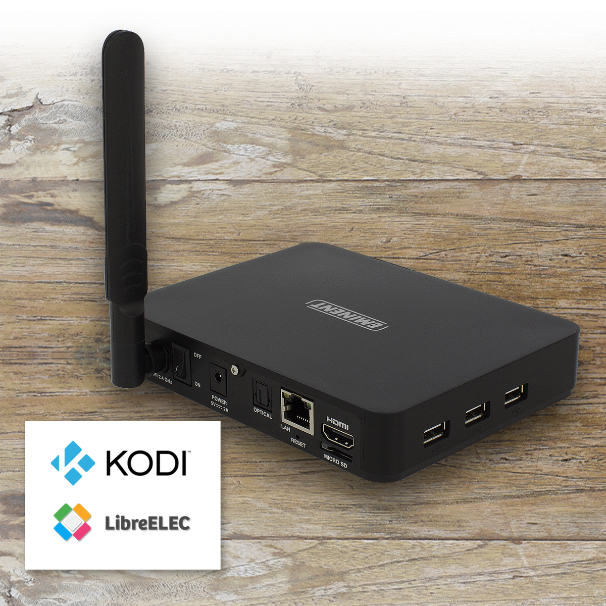 Un reproductor multimedia negro con antenas, puertos y las palabras Kodi y LibreELEC sobre una superficie de madera.