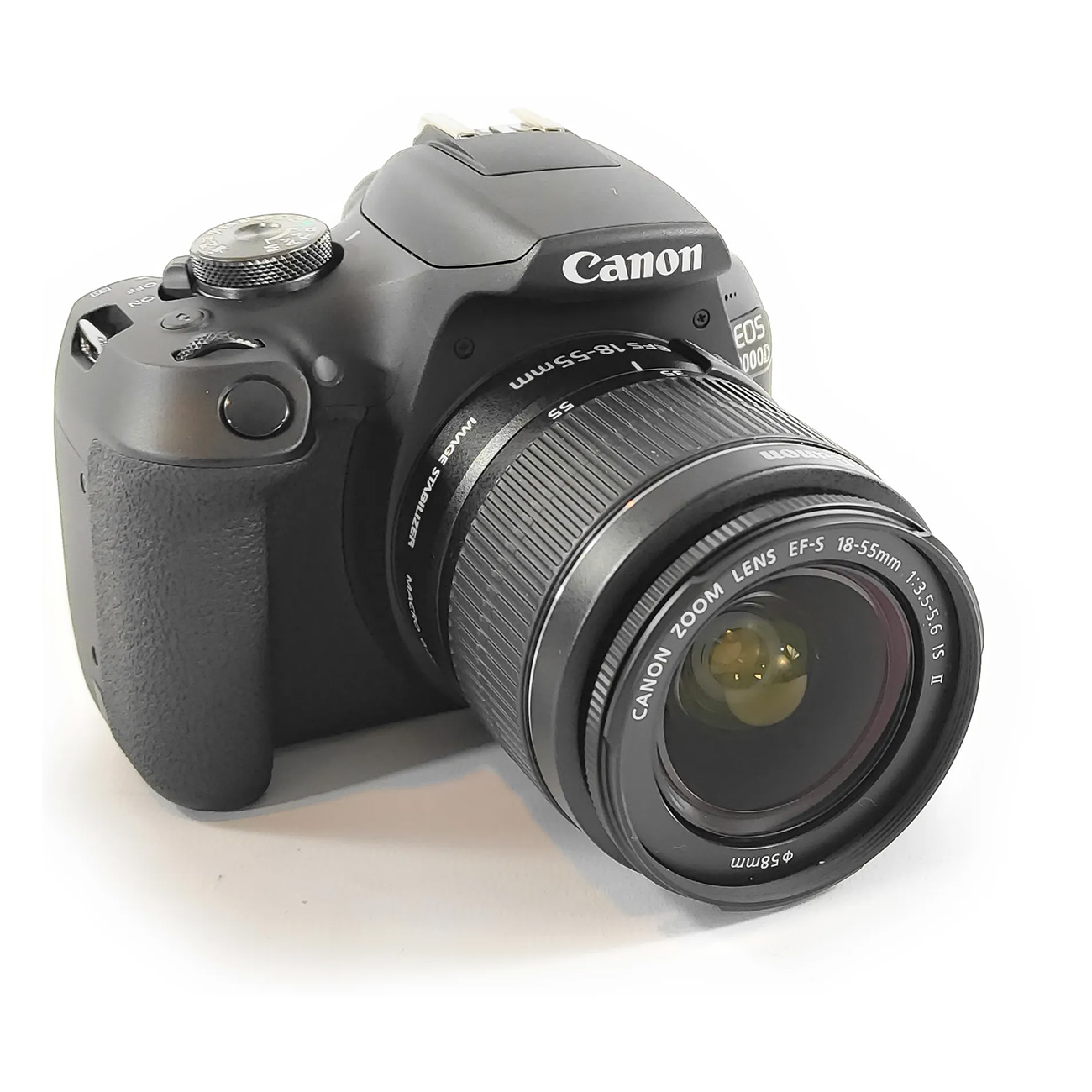 Fotocamera Canon nera con obiettivo, angolata su sfondo bianco.