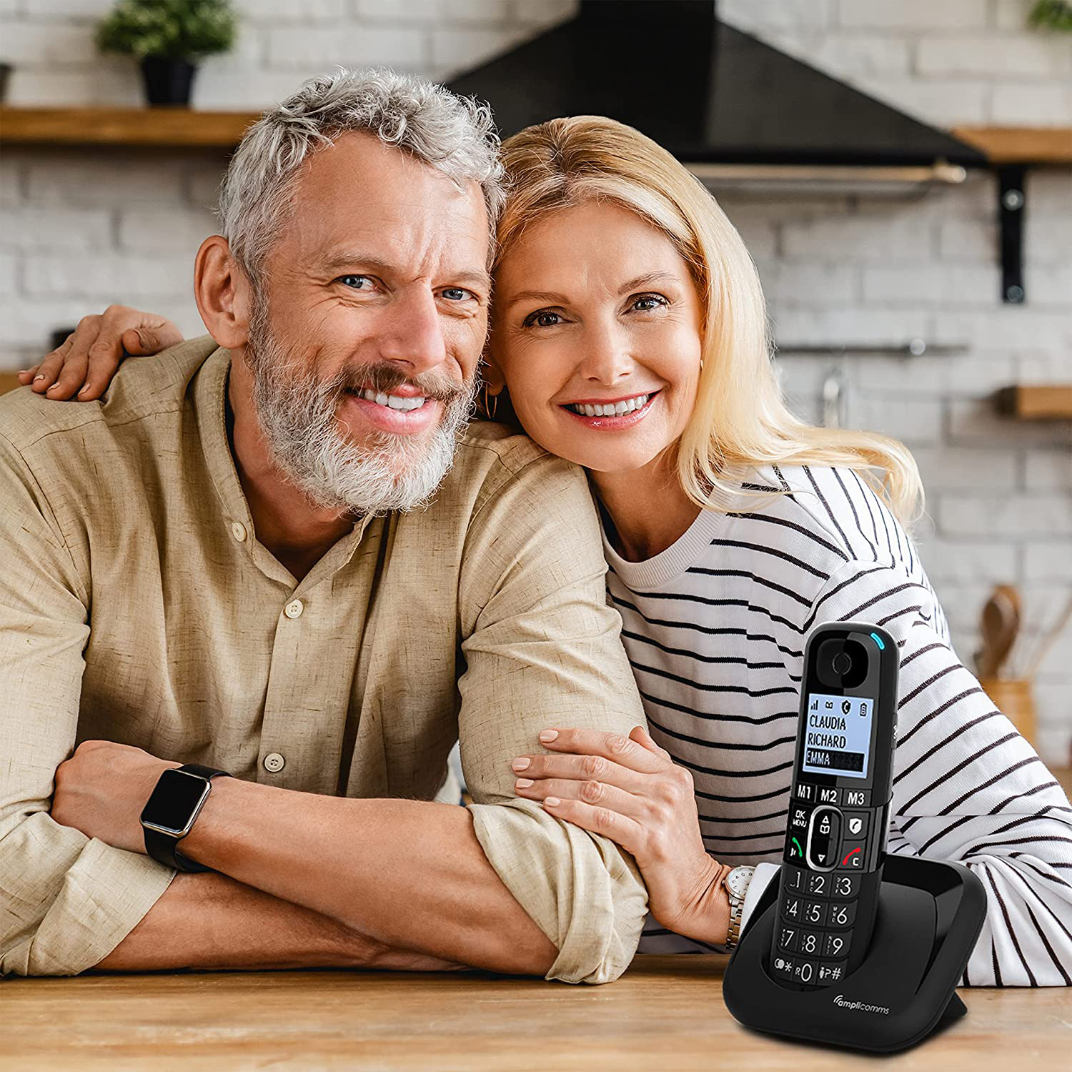Couple heureux avec téléphone fixe, souriant à la caméra.