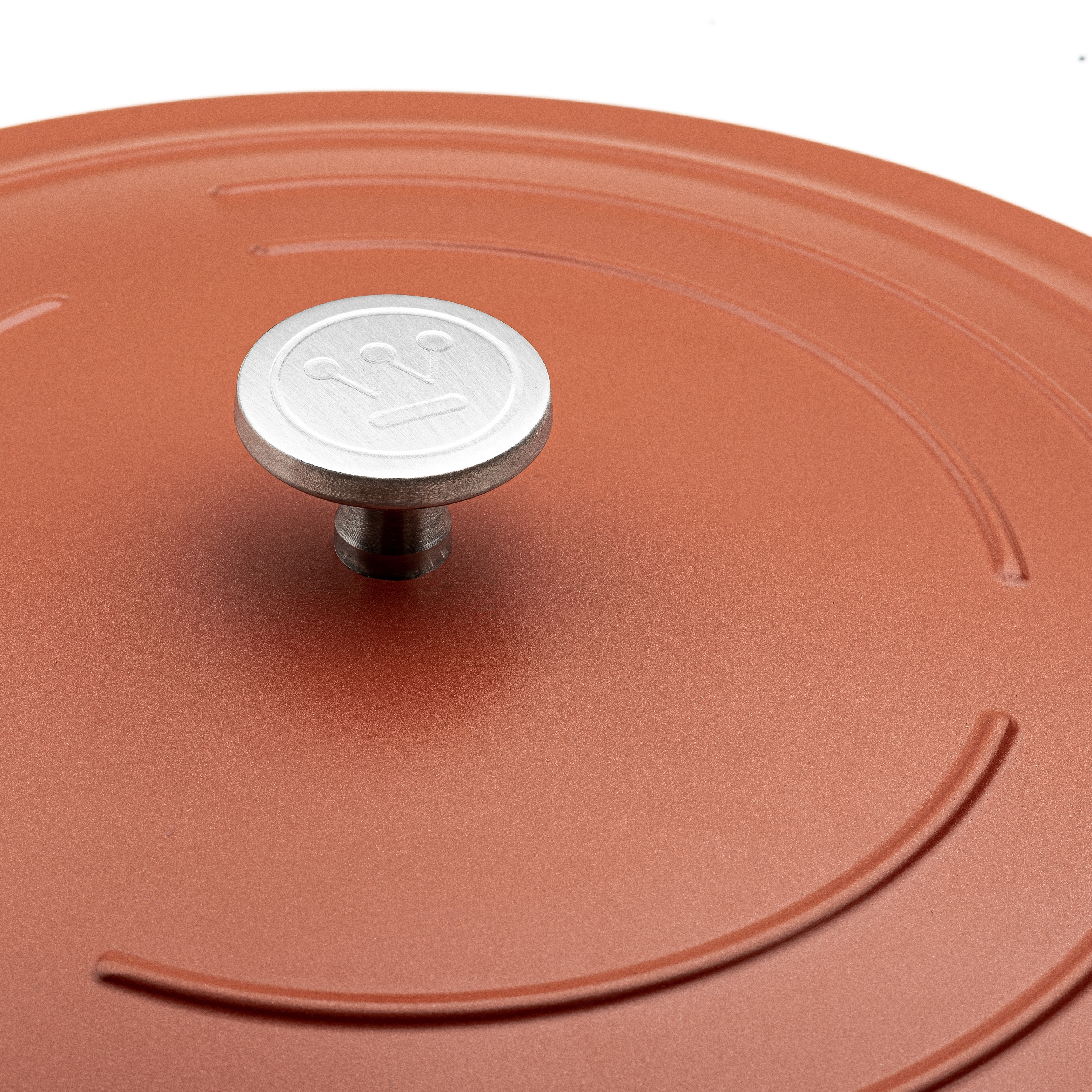 Nahaufnahme eines rot-orangen Kochtopfdeckels mit silbernem Griff mit 3 Kronen.