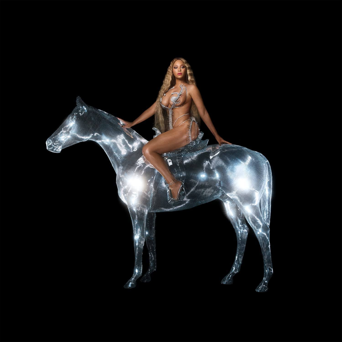 Beyoncé su un cavallo di cristallo, in abito d'argento su sfondo nero.