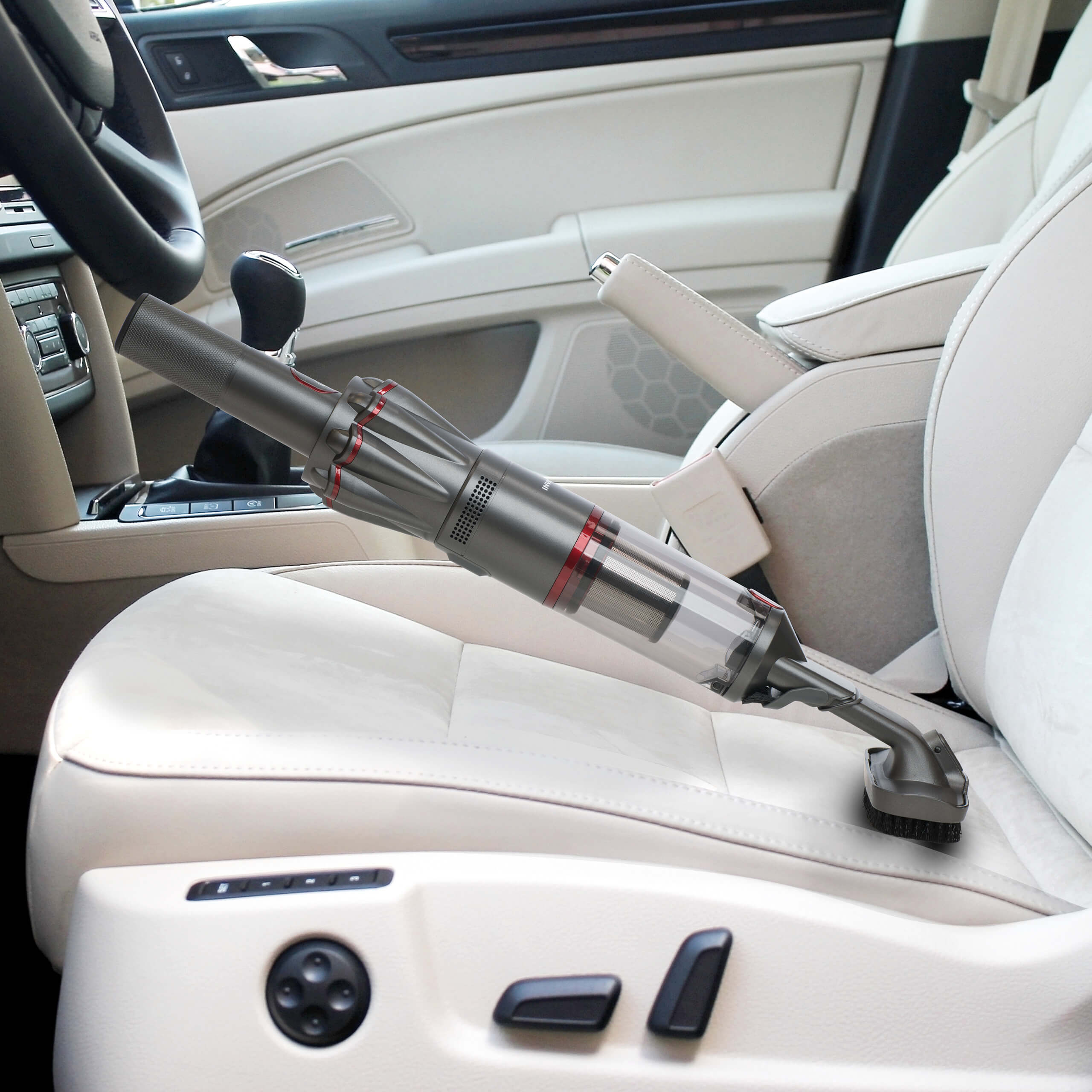 Ein Handstaubsauger reinigt einen Autositz. Der Innenraum des Autos ist hell.