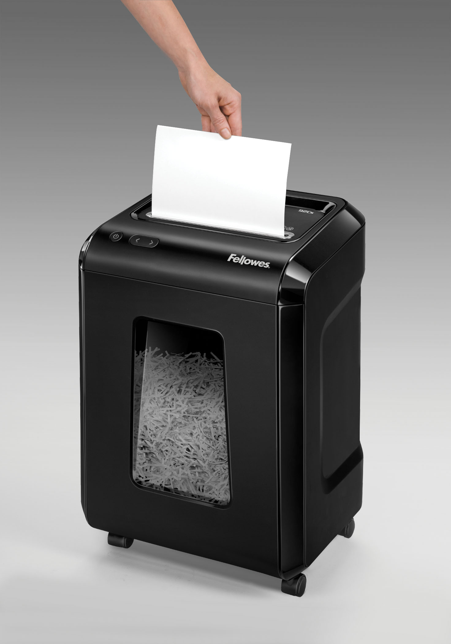 Ein schwarzer Aktenvernichter mit einer Hand, die ein weißes Blatt Papier zuführt.