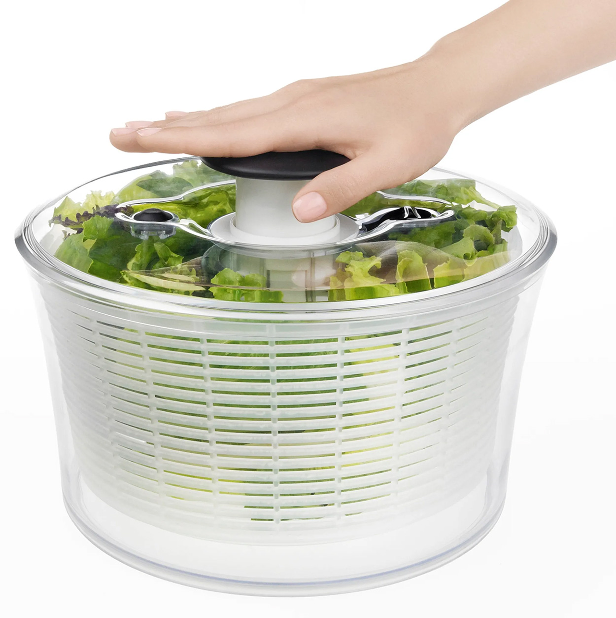 Hand über Salatschleuder mit Salat gefüllt.
