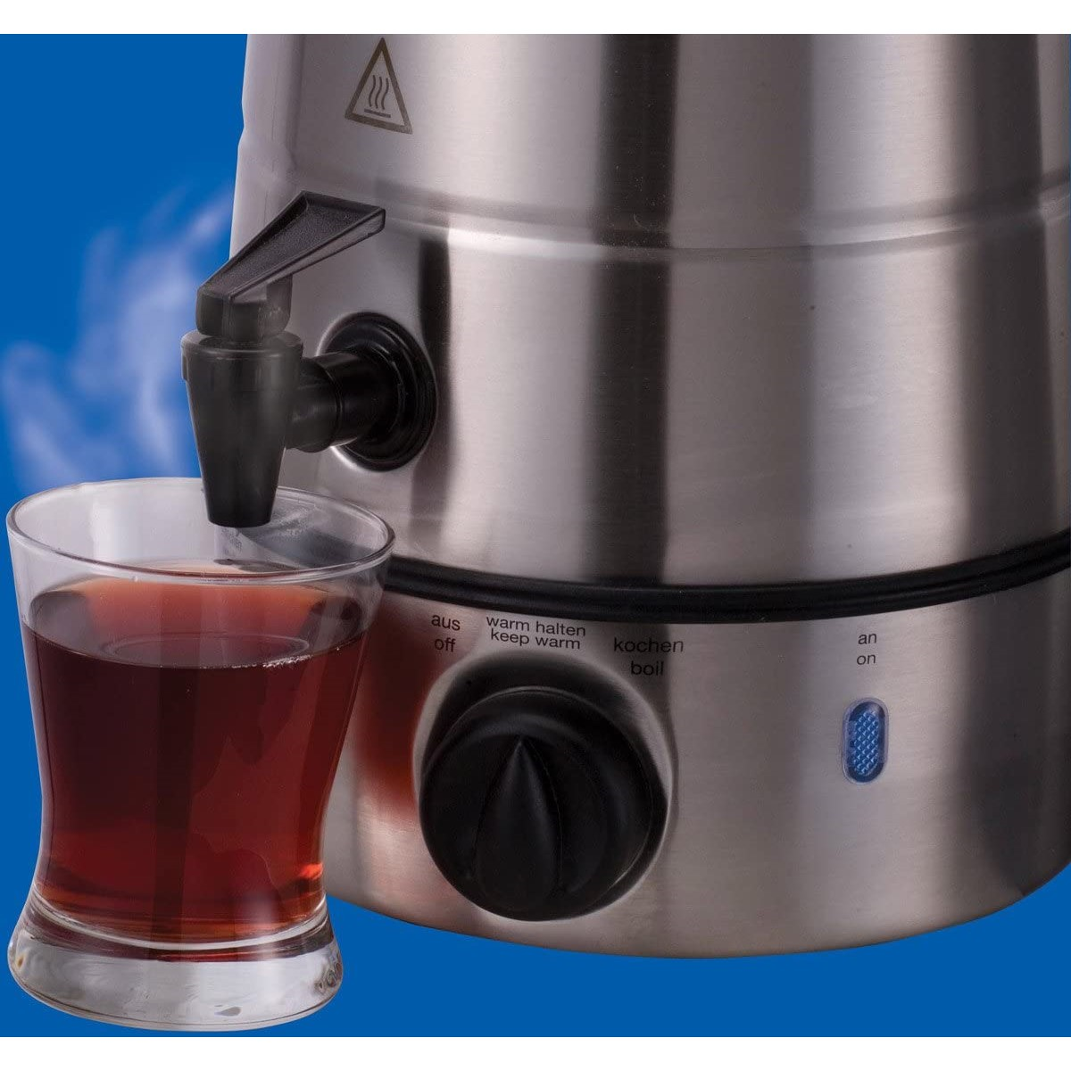 Ein silberner Wasserkocher mit einem Glas Tee. Er hat einen Ausguss und ein Zifferblatt mit Knöpfen.