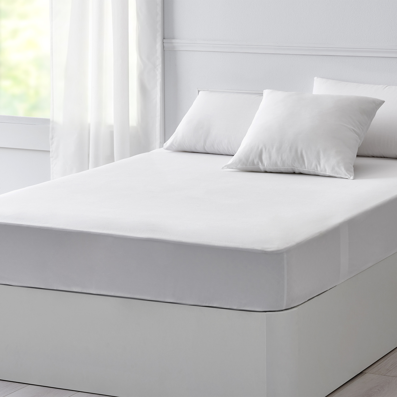 Una cama con un colchón blanco y dos almohadas. La cama tiene una base blanca.