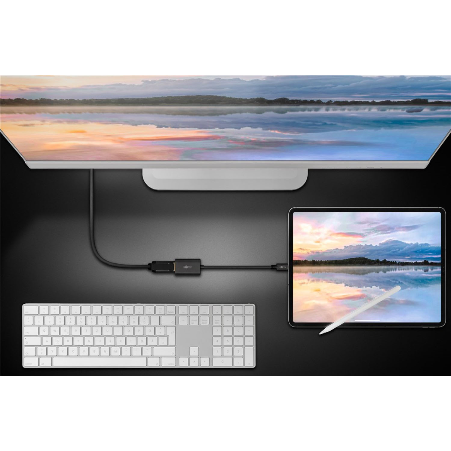 Ein Desktop-Setup mit Monitor, Tastatur und Tablet, verbunden durch schwarze Kabel.