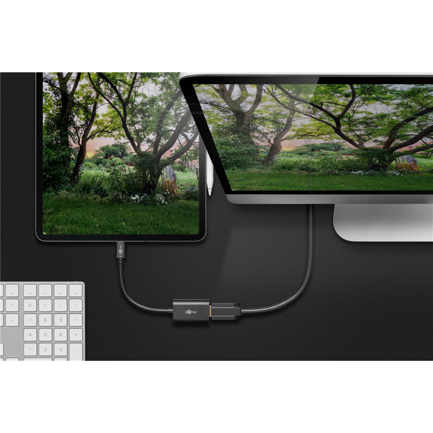 Tablet und Monitor mit Kabel verbunden, grüner Hintergrund.