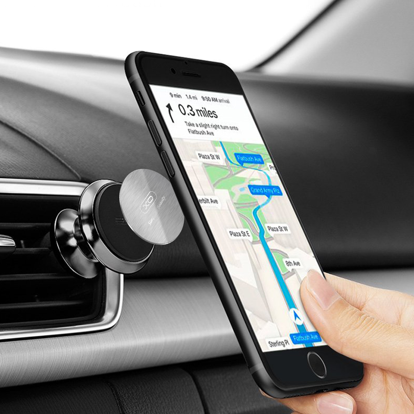 Un teléfono montado en la ventilación del coche muestra un mapa con indicaciones. Una mano se acerca al teléfono.